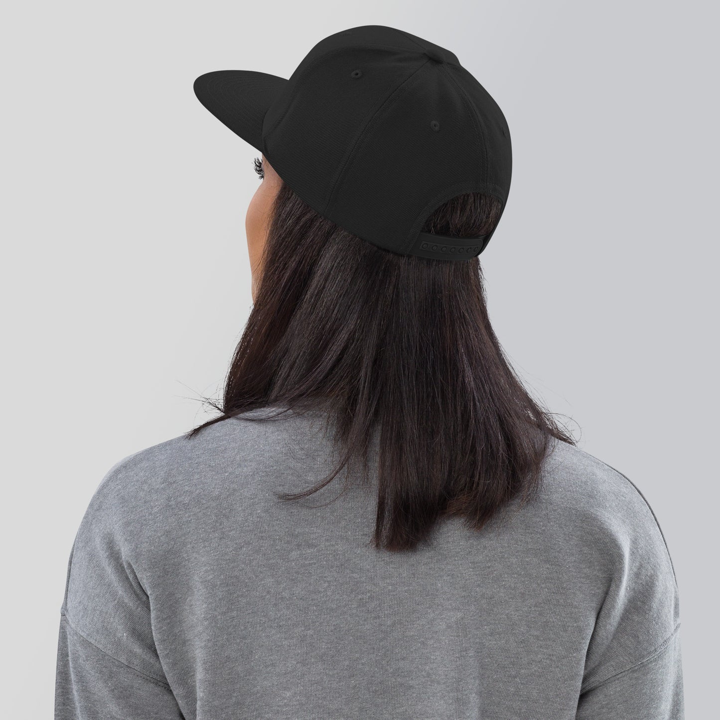 a woman wearing a black hat and grey shirt