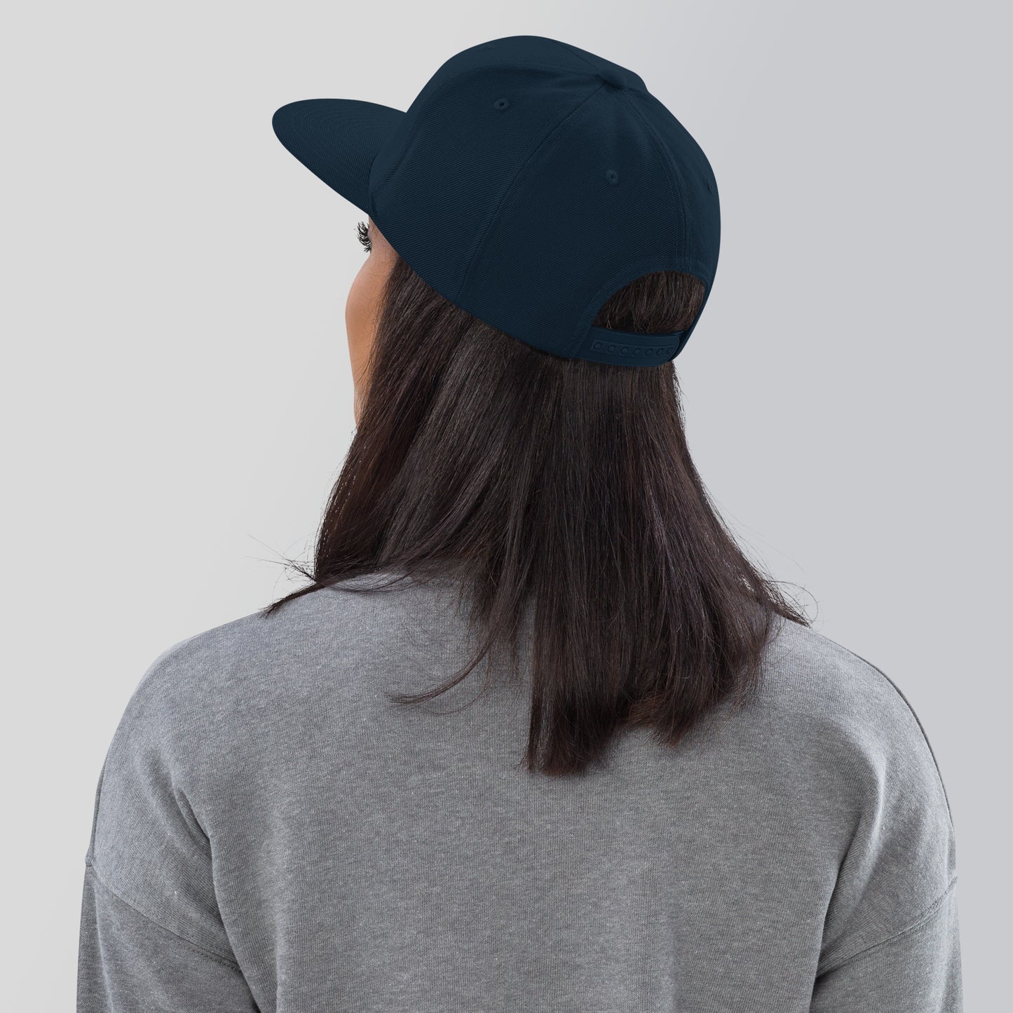a woman wearing a baseball cap and a gray shirt