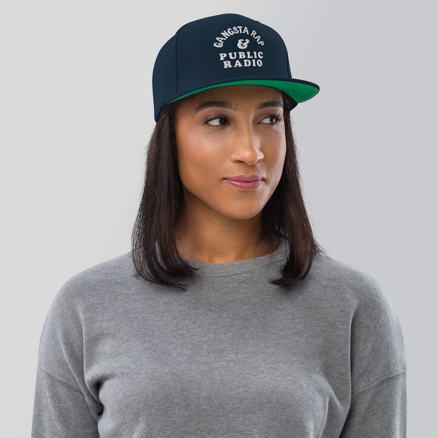 a woman wearing a gray shirt and a green hat