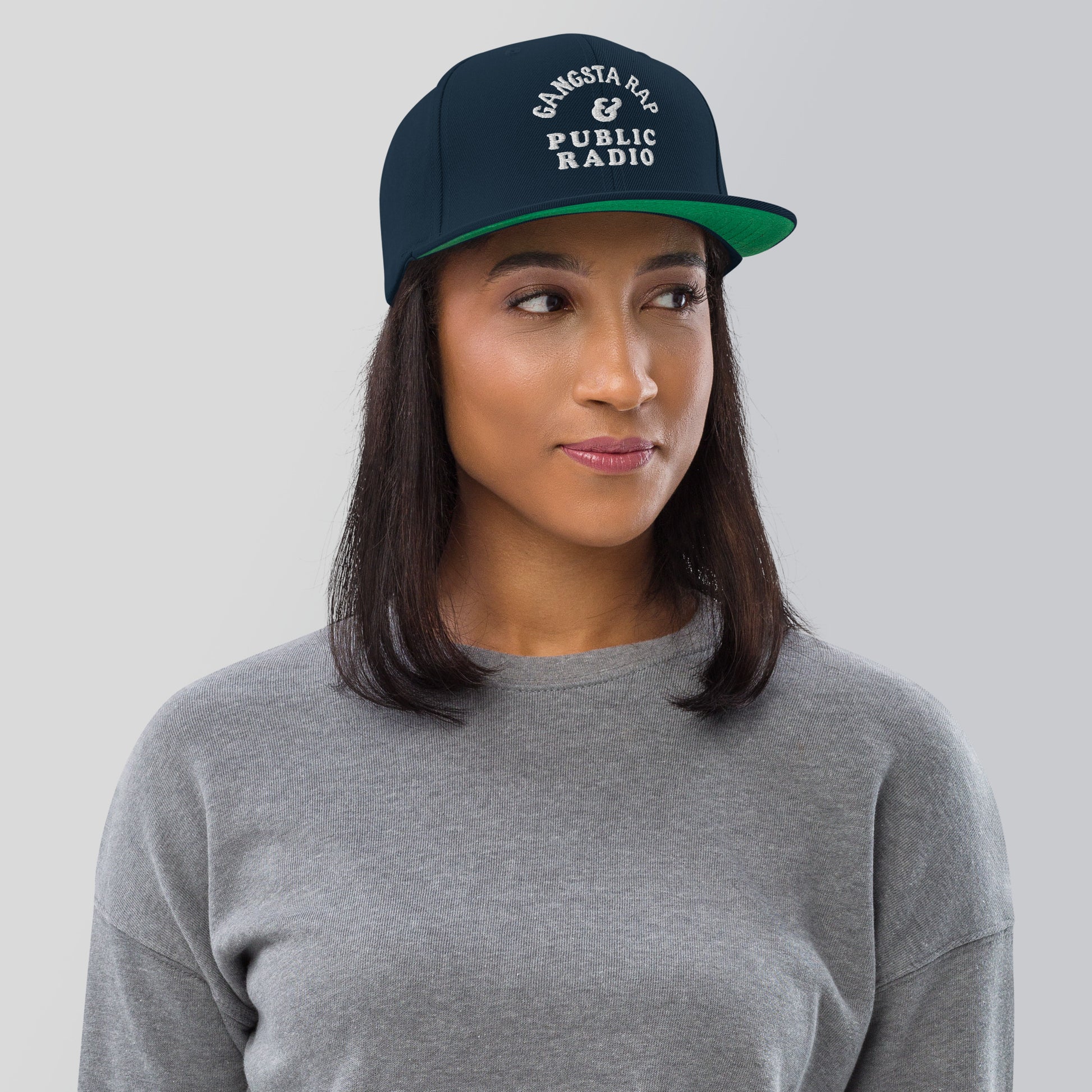 a woman wearing a gray shirt and a green hat