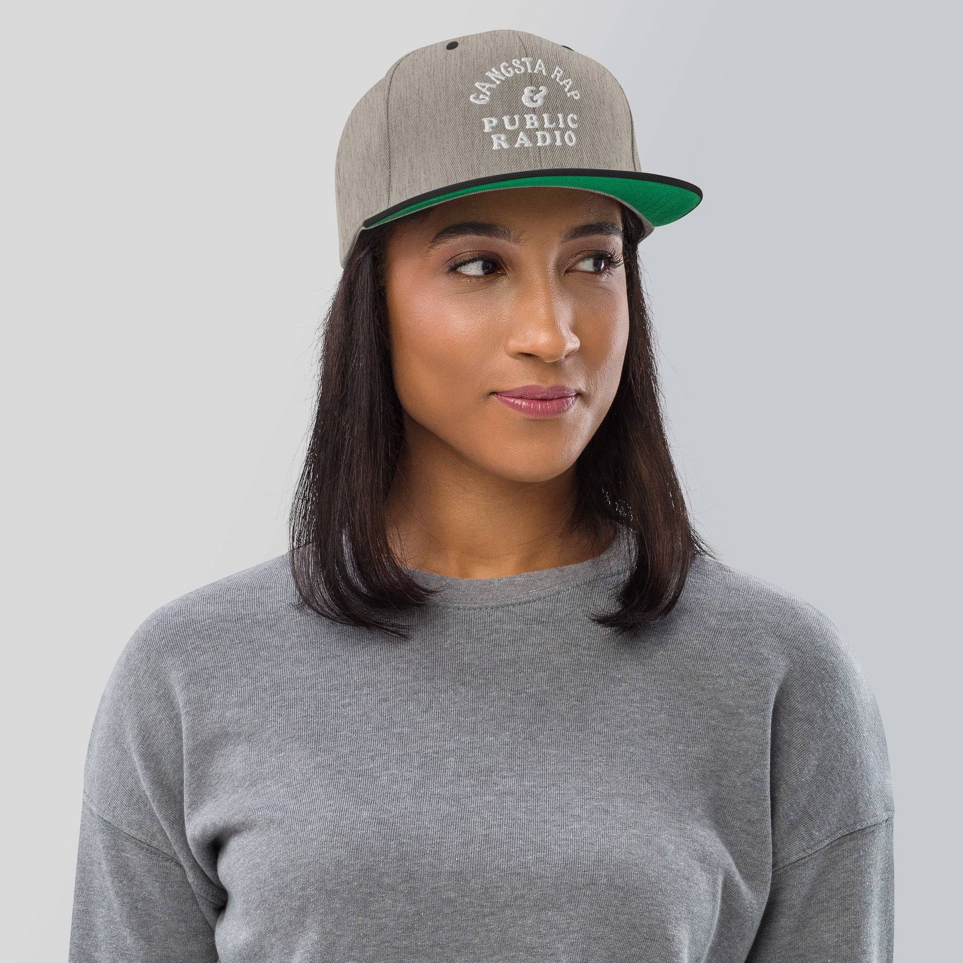a woman wearing a gray and green hat