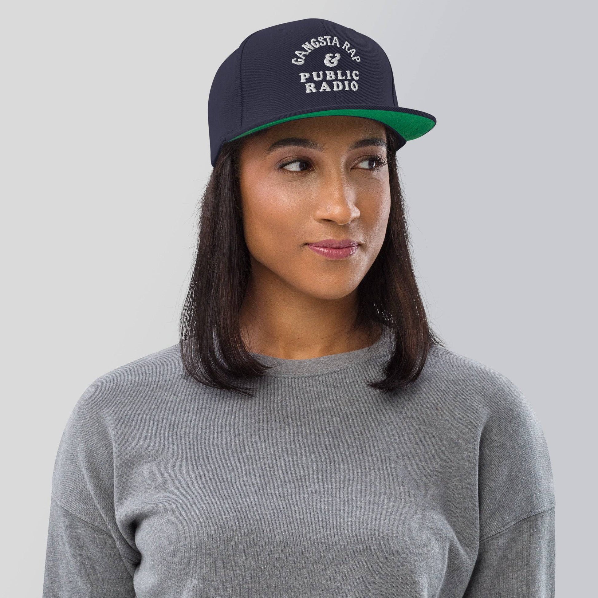 a woman wearing a gray shirt and a green hat