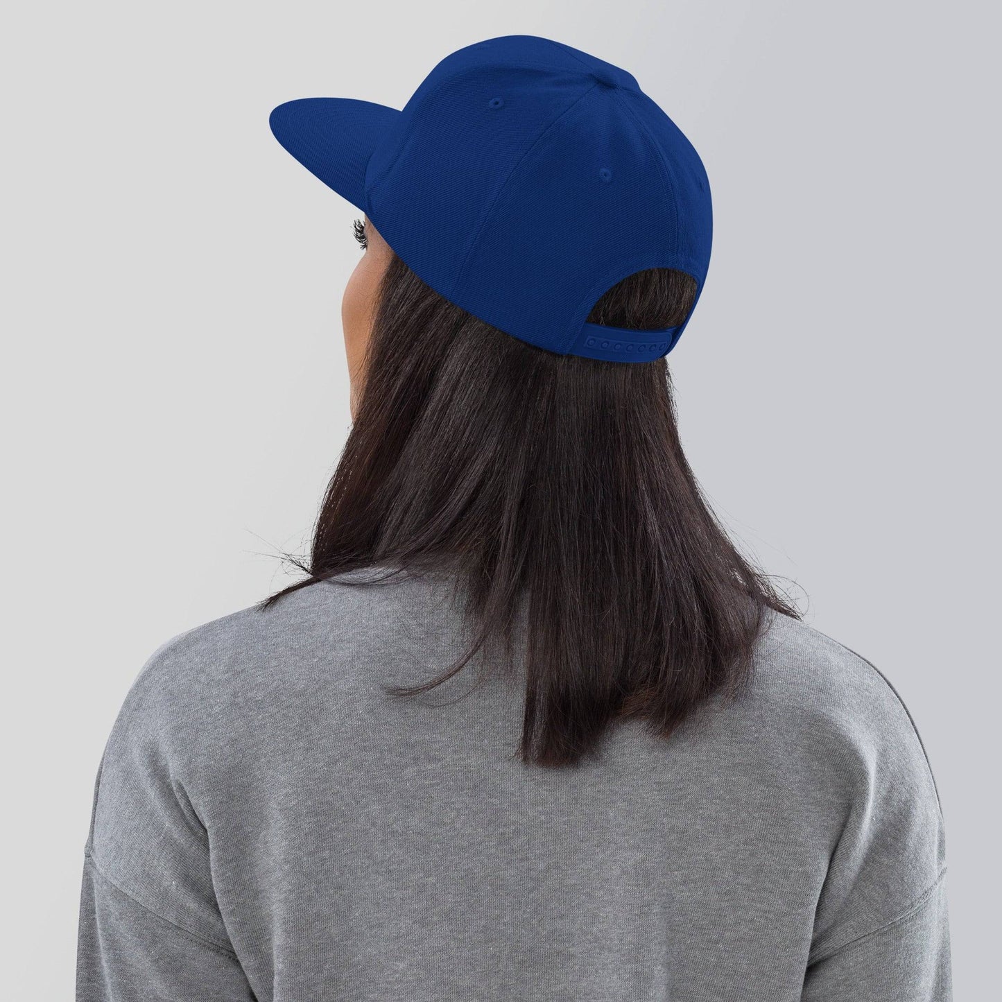 a woman wearing a blue hat and grey shirt