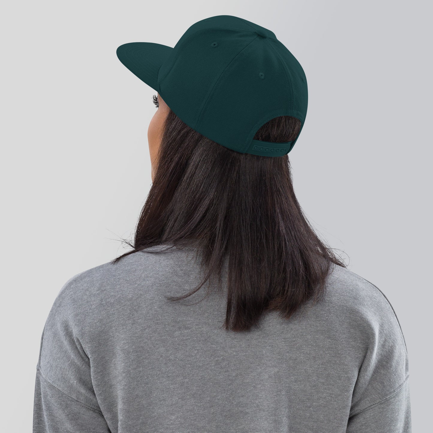 a woman wearing a green hat and grey shirt