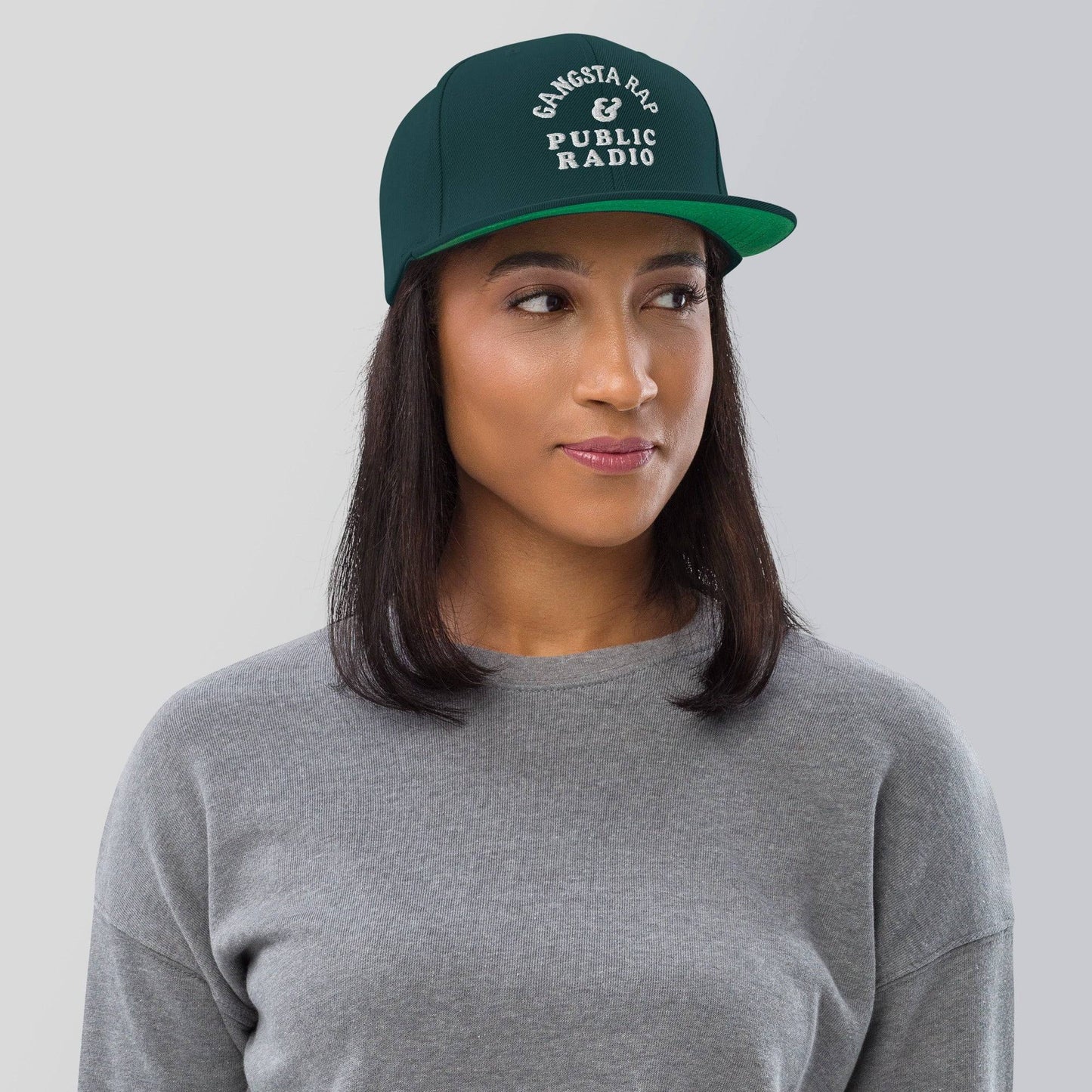 a woman wearing a gray shirt and a green hat