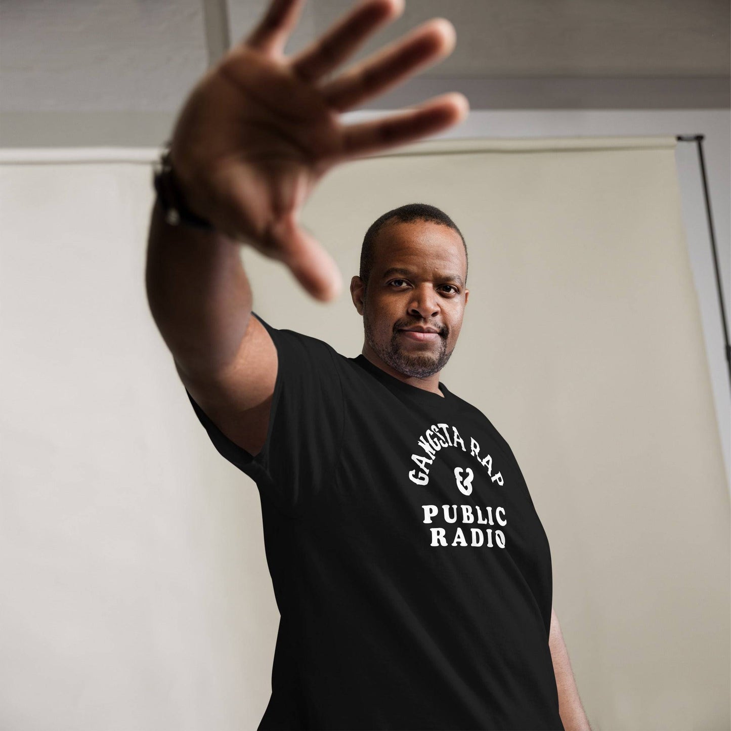 a man in a black shirt is holding his hand up