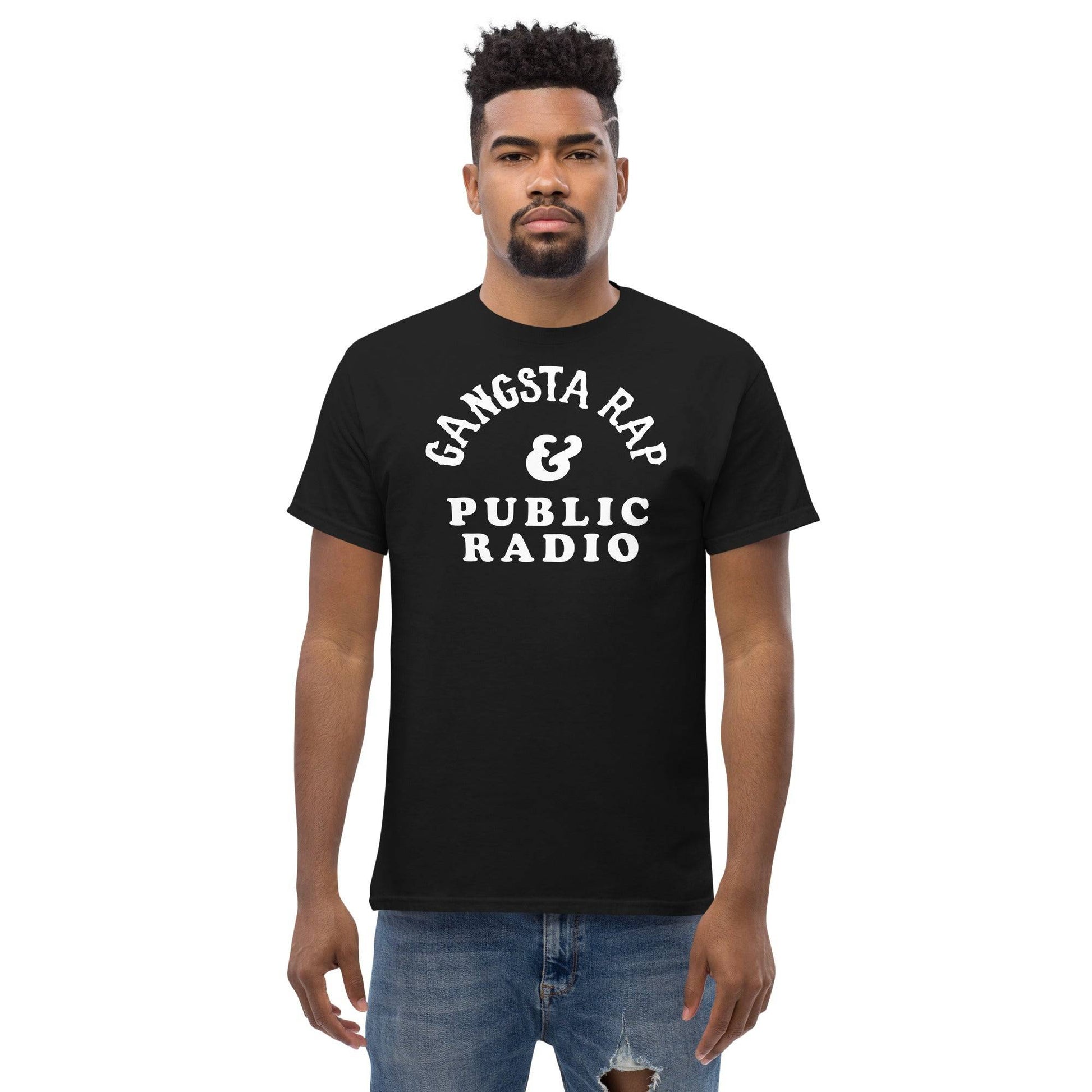 a man wearing a black t - shirt with white gansta rap and public radio writing on it