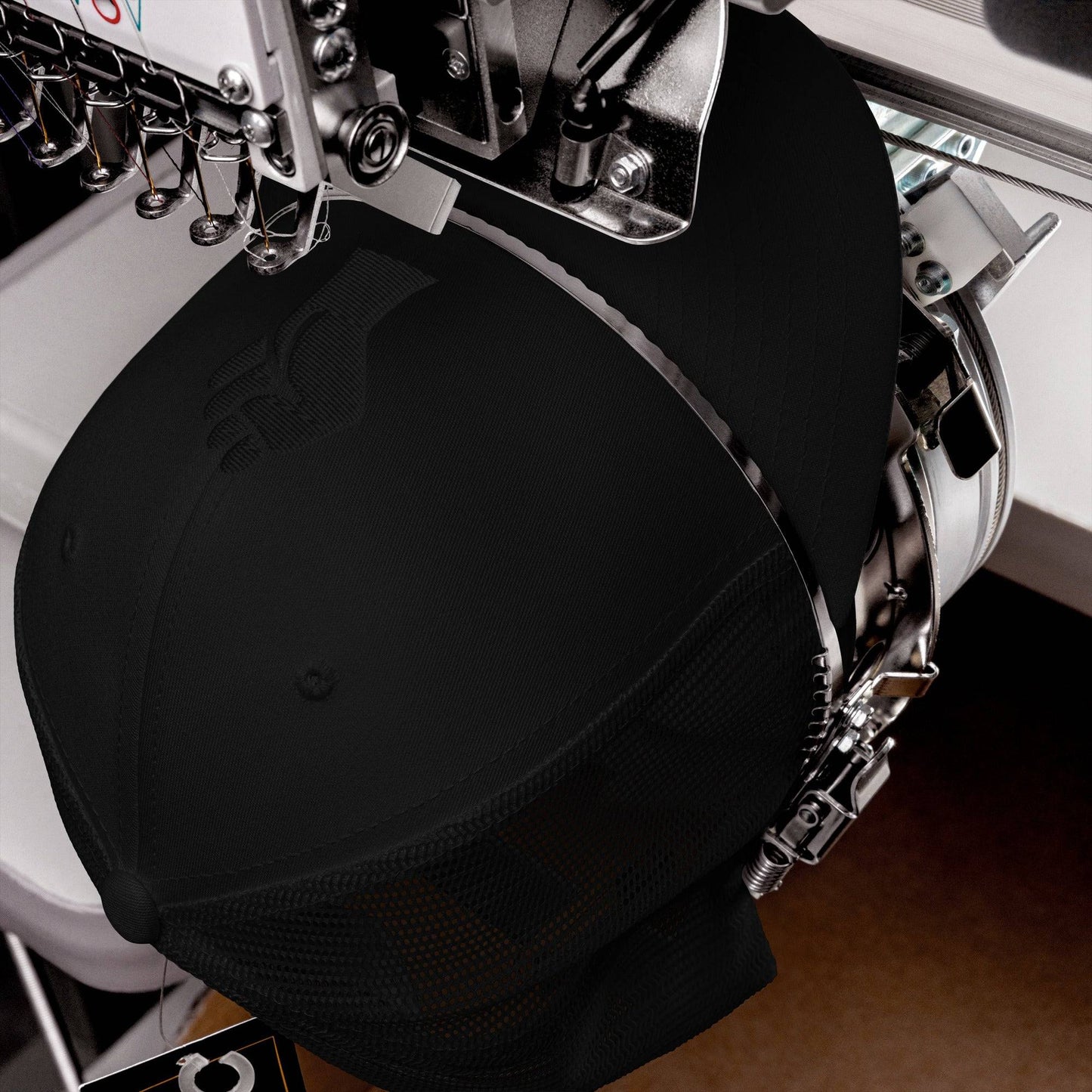 Embroidery machine stitching Black Power Fist on black trucker cap