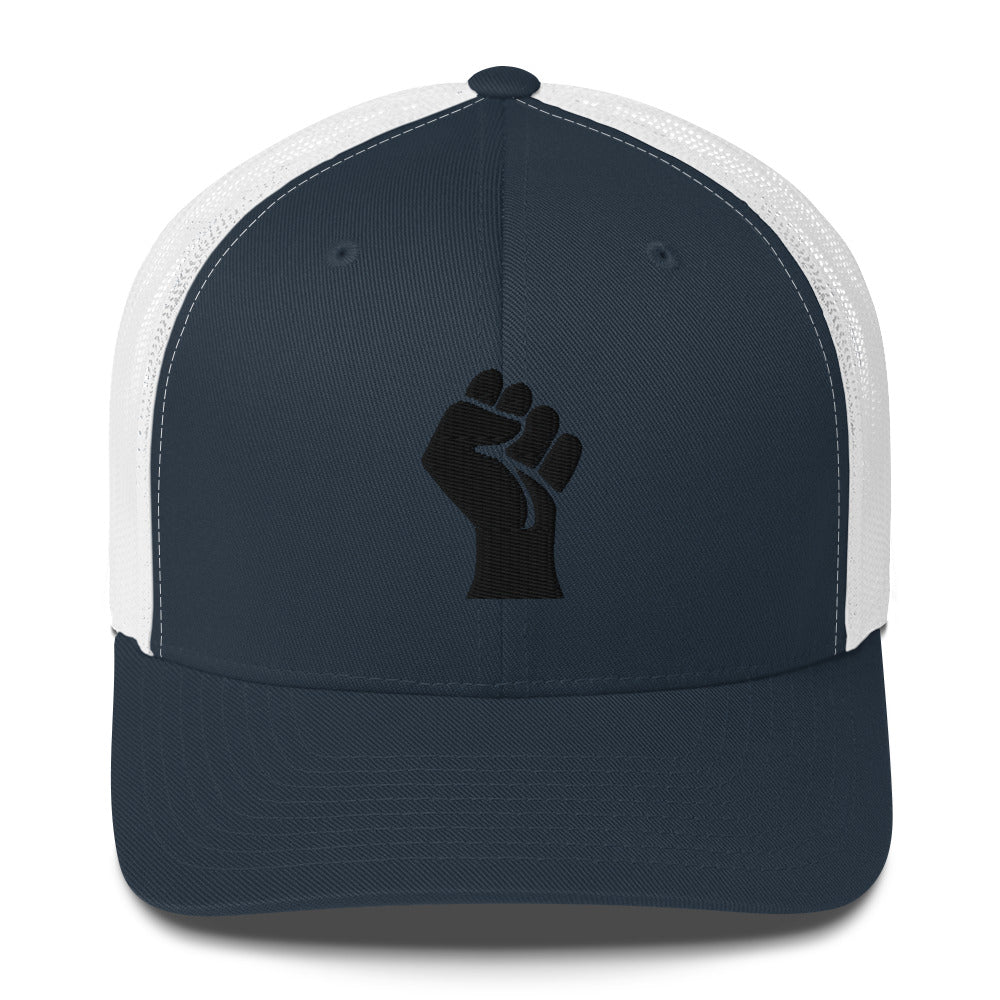 Front view of navy embroidered Black Power Fist trucker cap