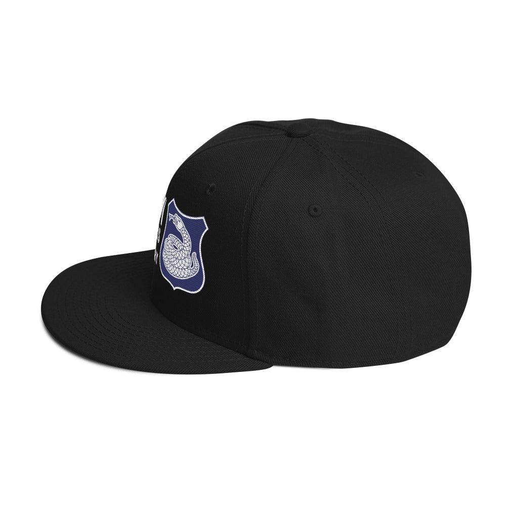 side view of a black hat with a white and purple rattlesnake crest on it with text that reads harlem hellfighters 369th infantry regiment