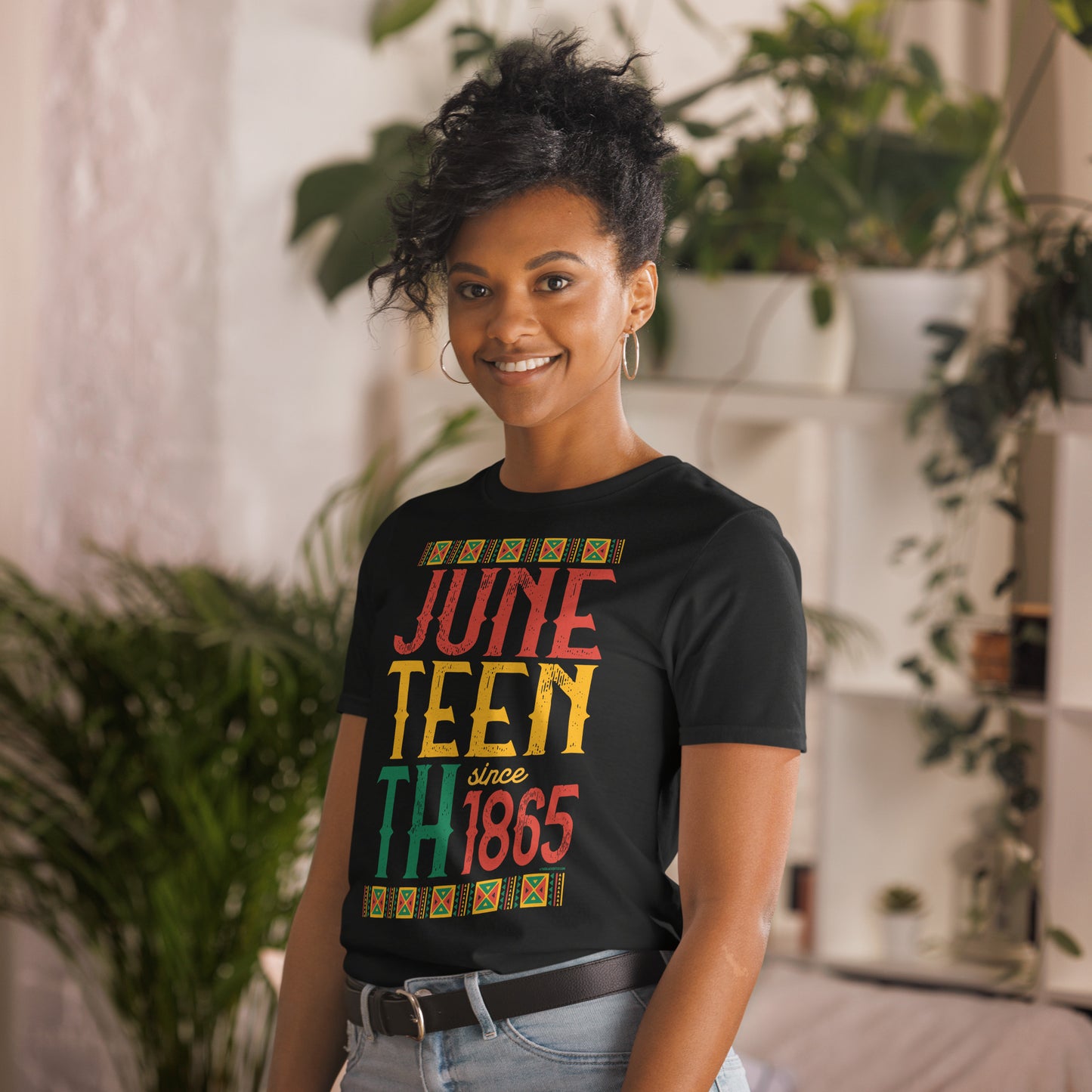 a woman standing in a room with a plant in the background wearing t - shirt that says juneteenth since 1865