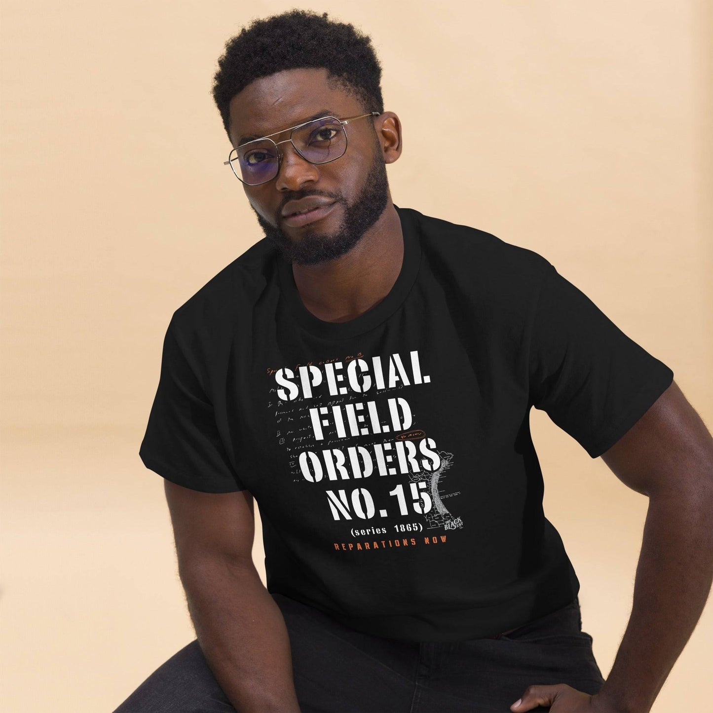Man seated wearing Special Field Order No. 15 Reparations T-Shirt, a bold Black-owned apparel statement on reparations.