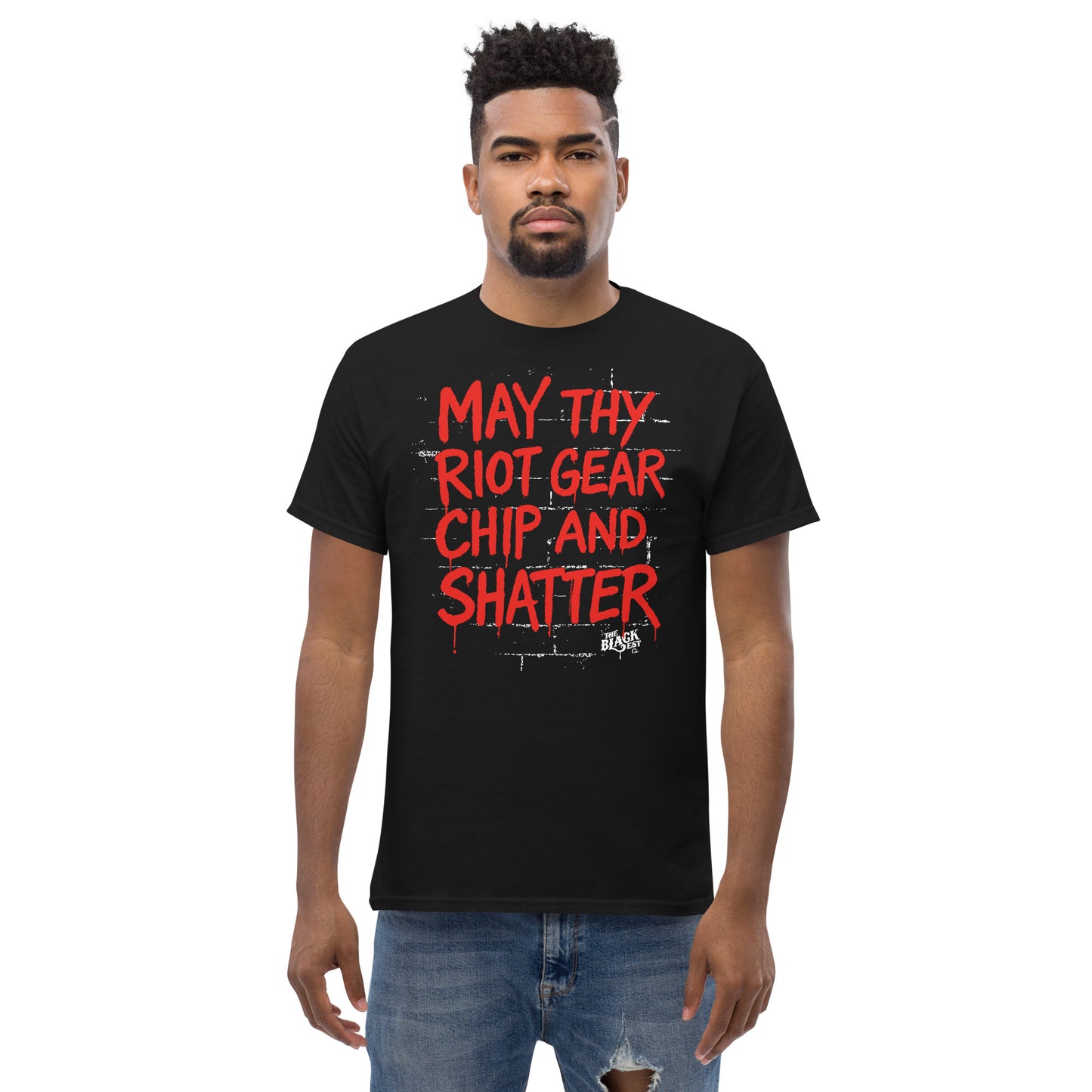 Model wearing black May Thy Riot Gear Chip And Shatter Staple T-Shirt by TheBlackest Co., featuring activist message in red graffiti font.