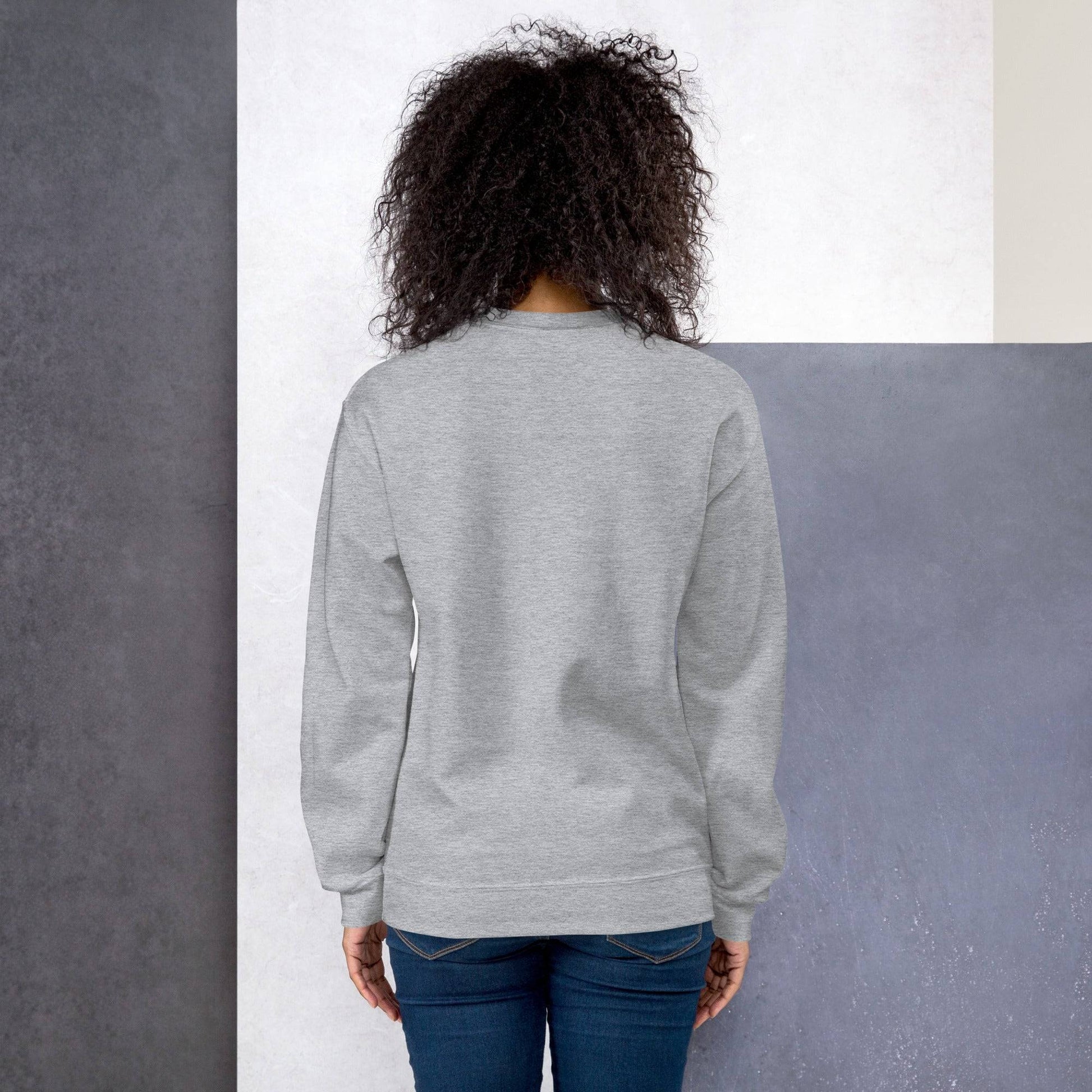 a woman standing in front of a wall with her back to the camera