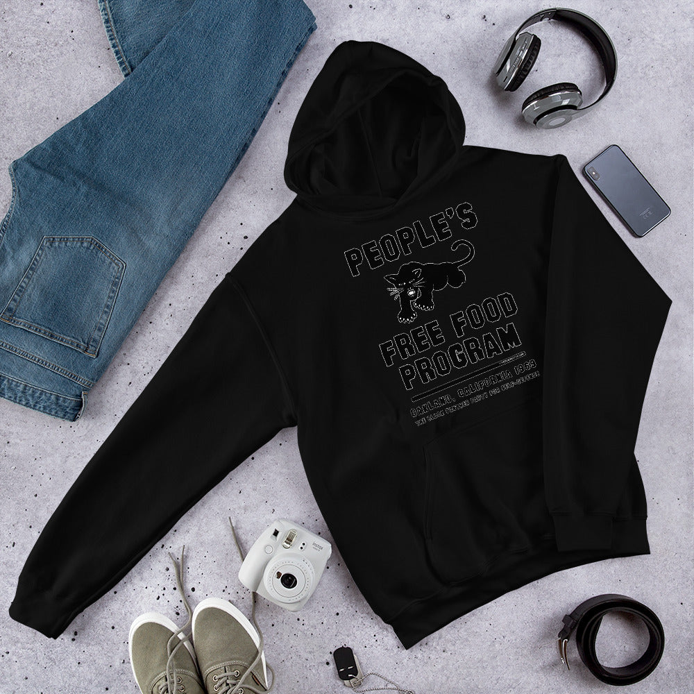 Flat lay of Black On Black BPP Free Food Program Staple Hoodie with accessories, emphasizing streetwear appeal and bold activist design.