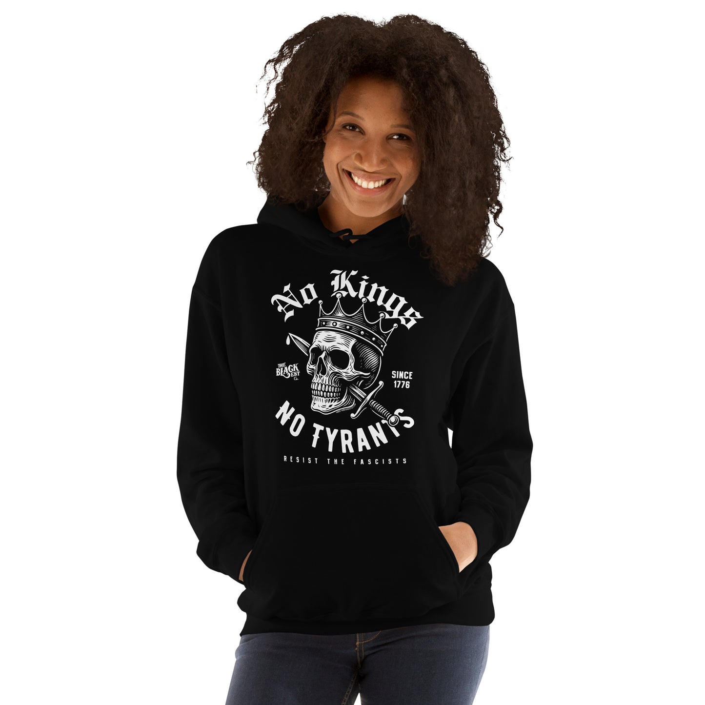 Woman posing confidently in No Kings No Tyrants Skull Protest Hoodie by TheBlackest Co., a unisex pullover with bold skull and anti-fascist print.