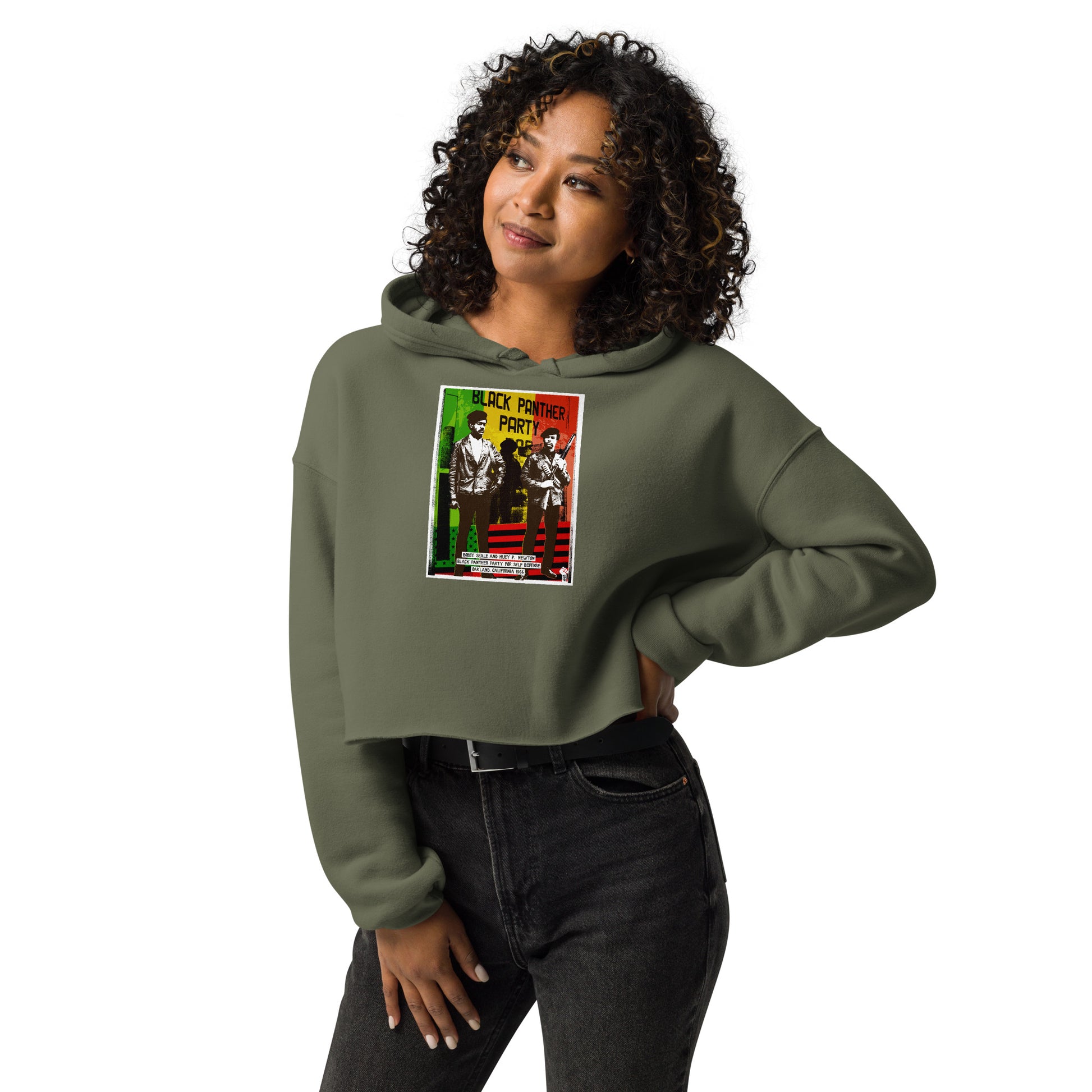 Model wearing The Black Panther Party BPP Storefront Crop Hoodie in olive green, styled with black jeans for a bold cultural fashion statement.