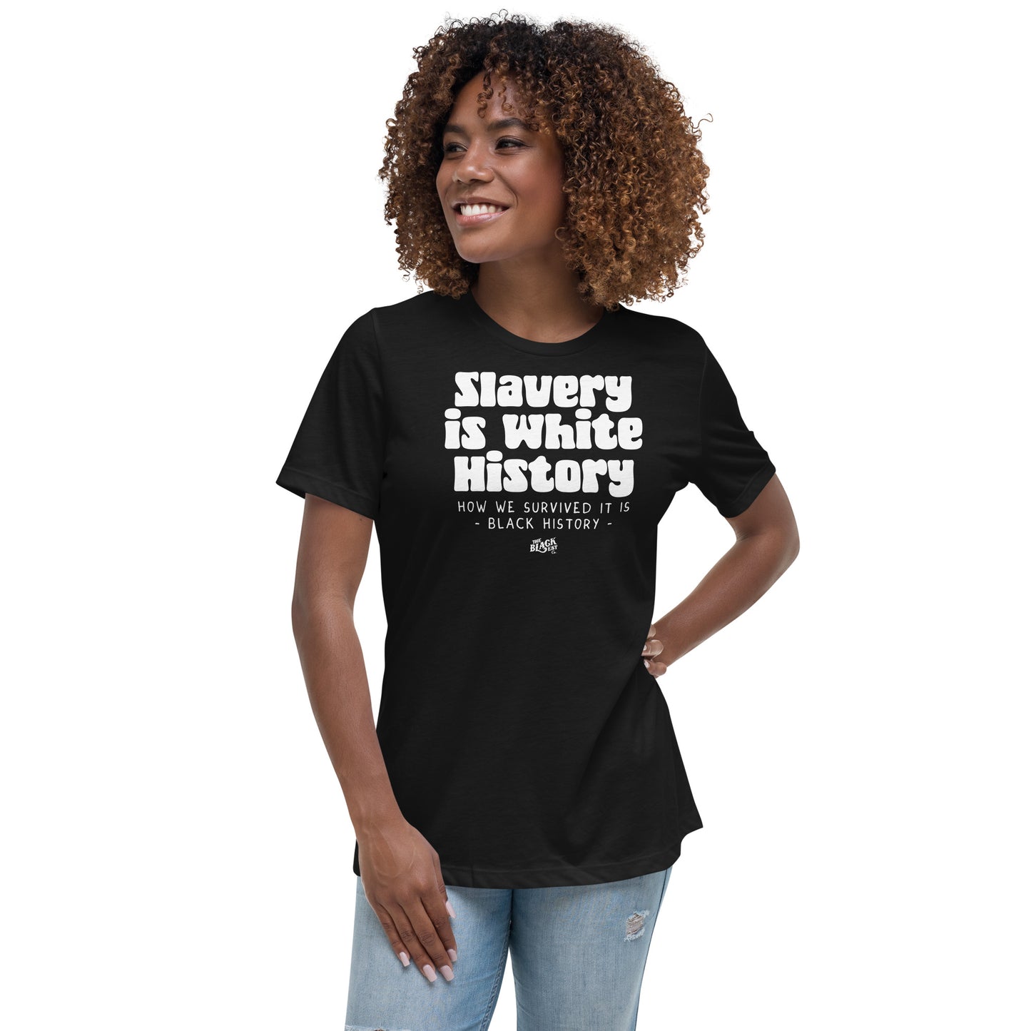 Woman wearing a black 'Slavery Is White History' t-shirt, standing confidently. A bold statement piece for Black history awareness and empowerment.