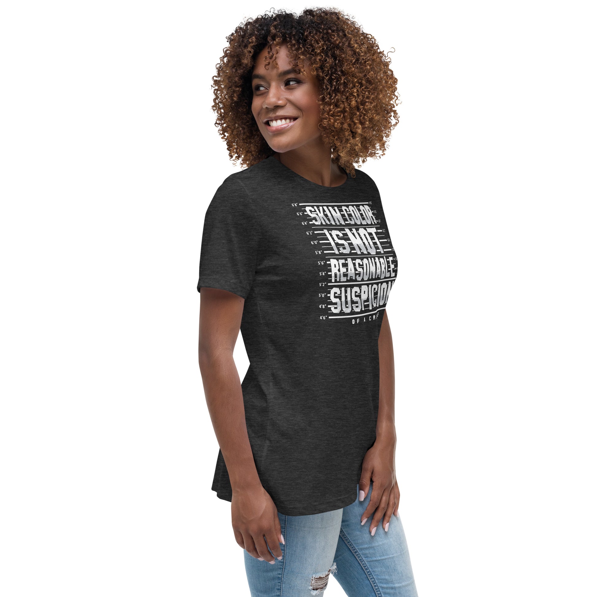 Woman wearing charcoal 'Skin Color Is Not Reasonable Suspicion' relaxed-fit t-shirt. Feminist and anti-racism graphic tee for casual activism.