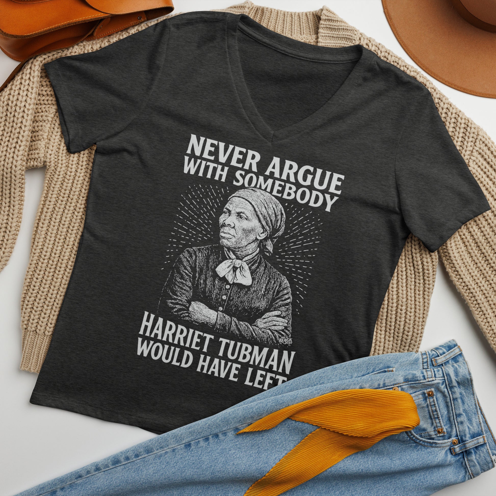 Flat lay of Never Argue With Somebody Harriet Tubman Womens Relaxed V-Neck styled with jeans, sweater, and hat for casual fashion inspiration.