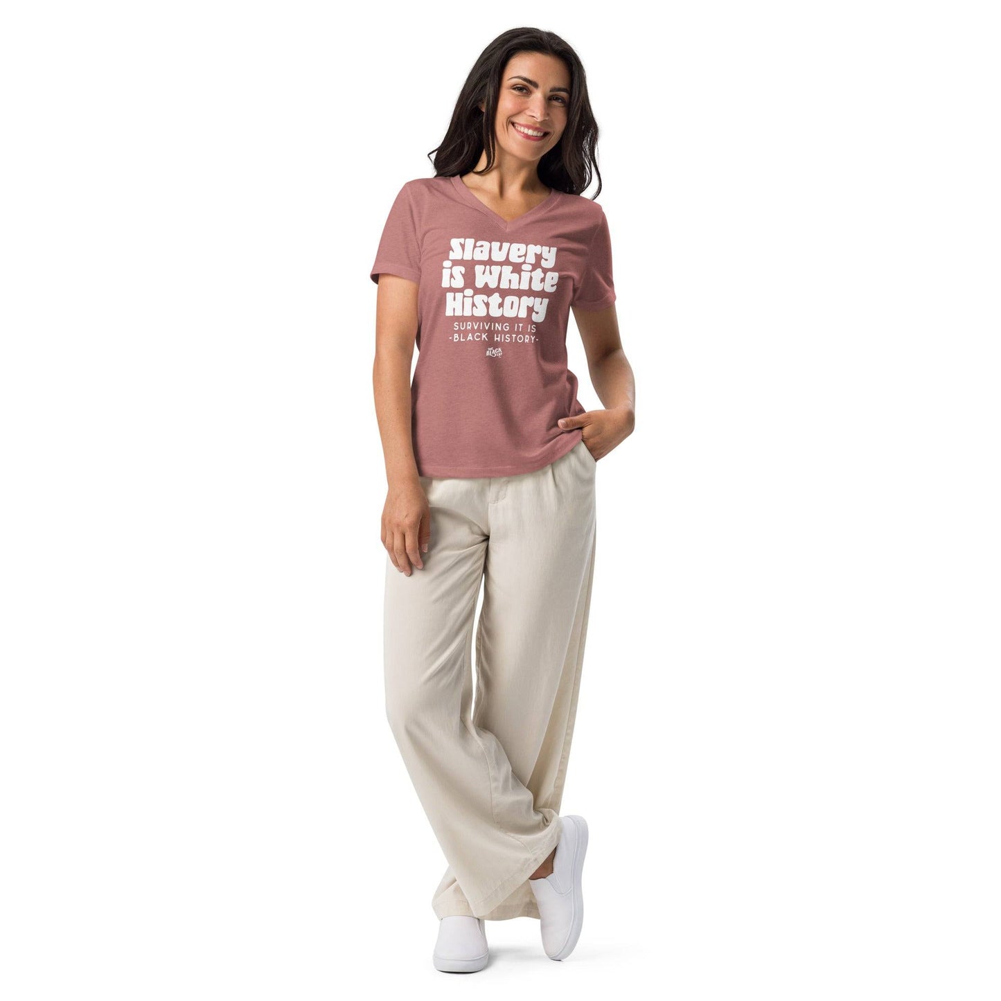 Woman wearing the ALLY Slavery Is White History Women's V-neck T-shirt in mauve, styled with cream pants for a casual, empowering fashion statement.