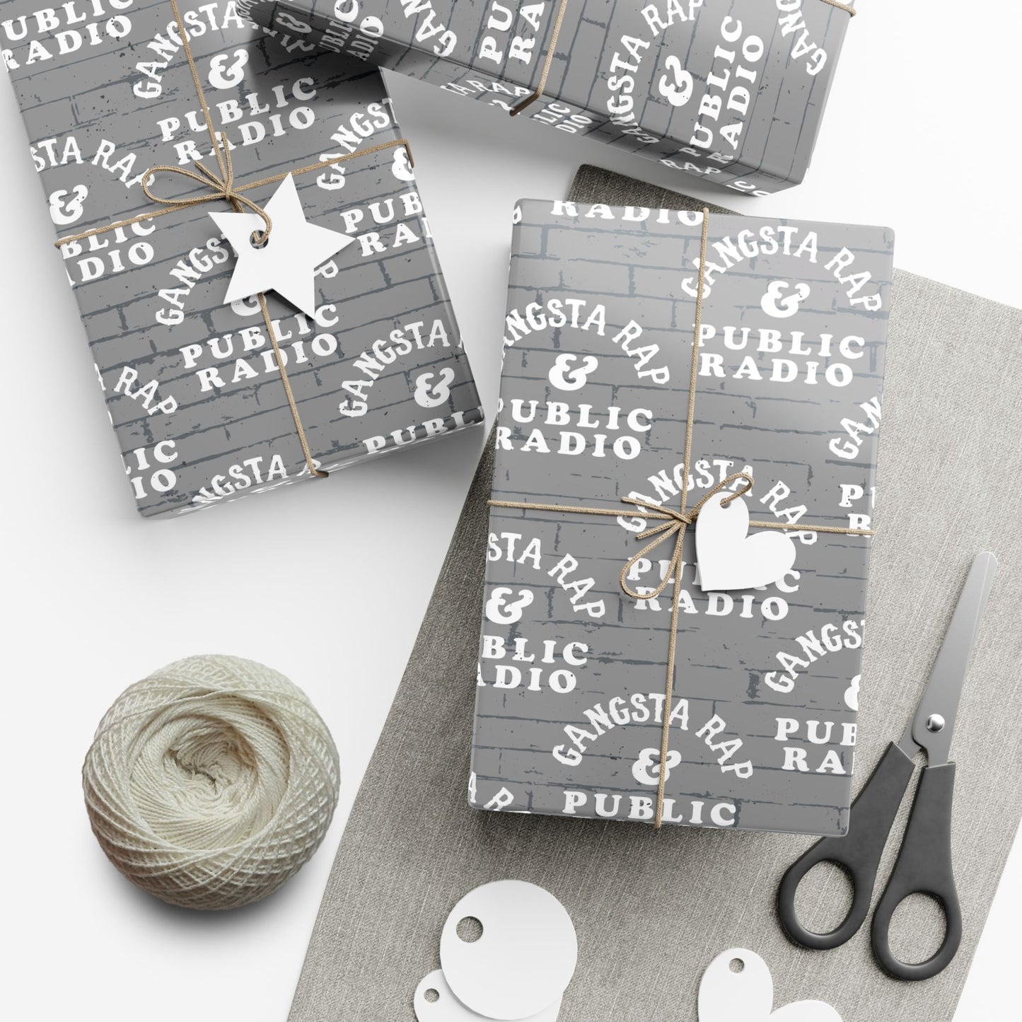 Gangsta Wrap & Public Radio Christmas Gift Wrapping Paper on presents with twine and tags, ideal for music lovers and holiday gift giving.