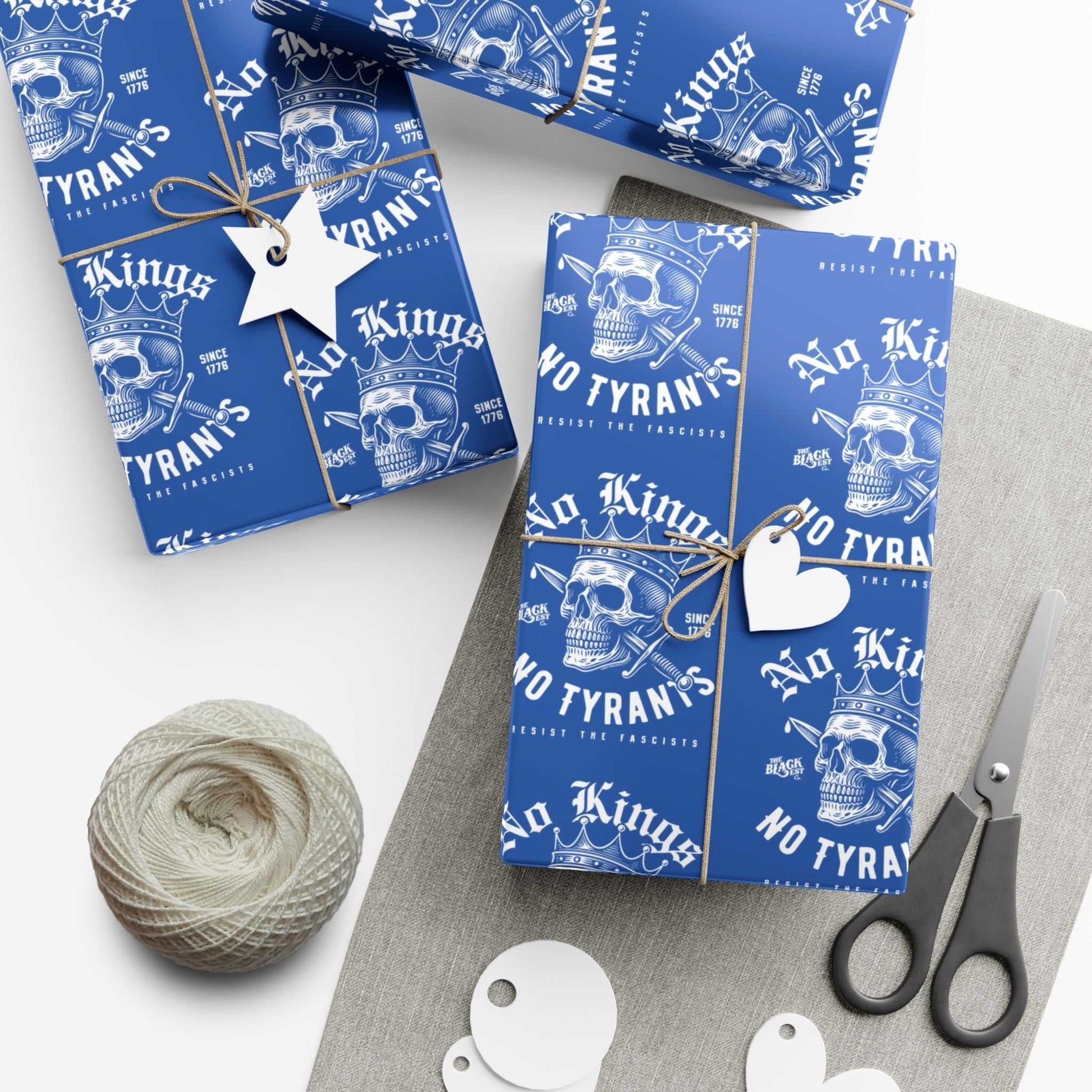 Wrapped gifts using No Kings No Tyrants Christmas Gift Wrapping Paper by TheBlackest Co., featuring skull art and protest slogans in white on blue.