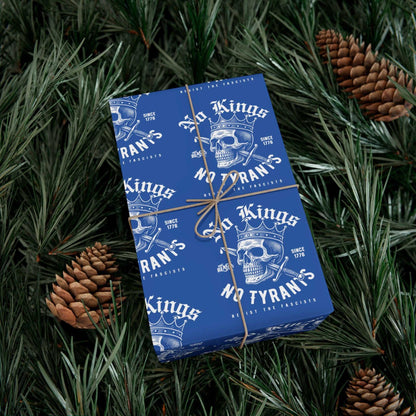 Gift box wrapped in No Kings No Tyrants Christmas Gift Wrapping Paper by TheBlackest Co., placed on pine branches for a bold holiday presentation.