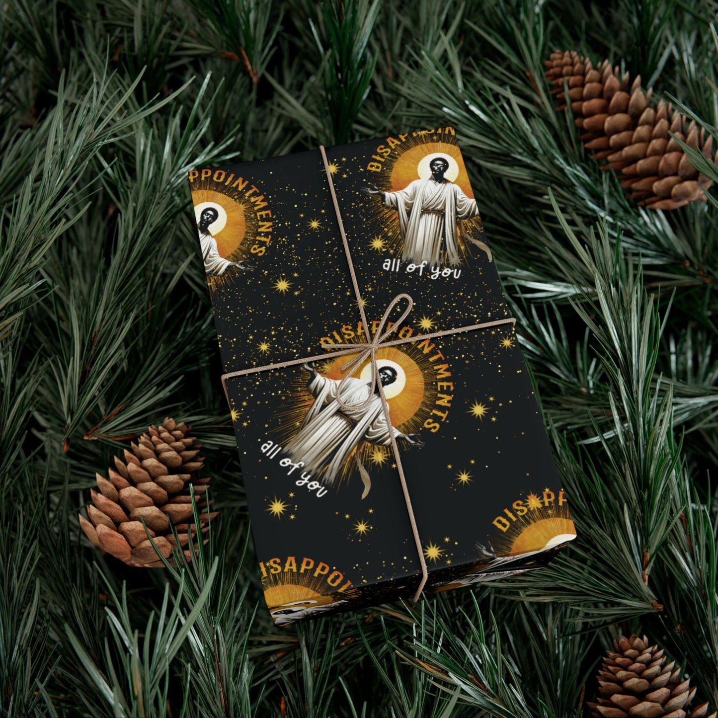 Wrapped gift in Black Jesus Disappointments All Of You Christmas Gift Wrap placed on pine branches, perfect for festive and eco-friendly presentation.