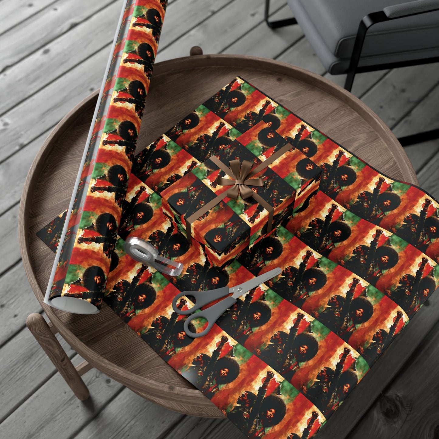 PanAfrican Christmas Wrapping Paper with bold Black empowerment imagery, laid out on a table with scissors and ribbon for festive gift wrapping.