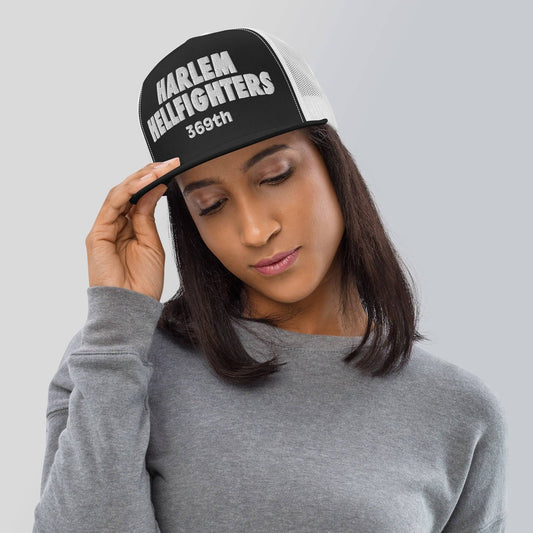 woman wearing a black and white trucker hat with harlem hellfighters 369th embroidery