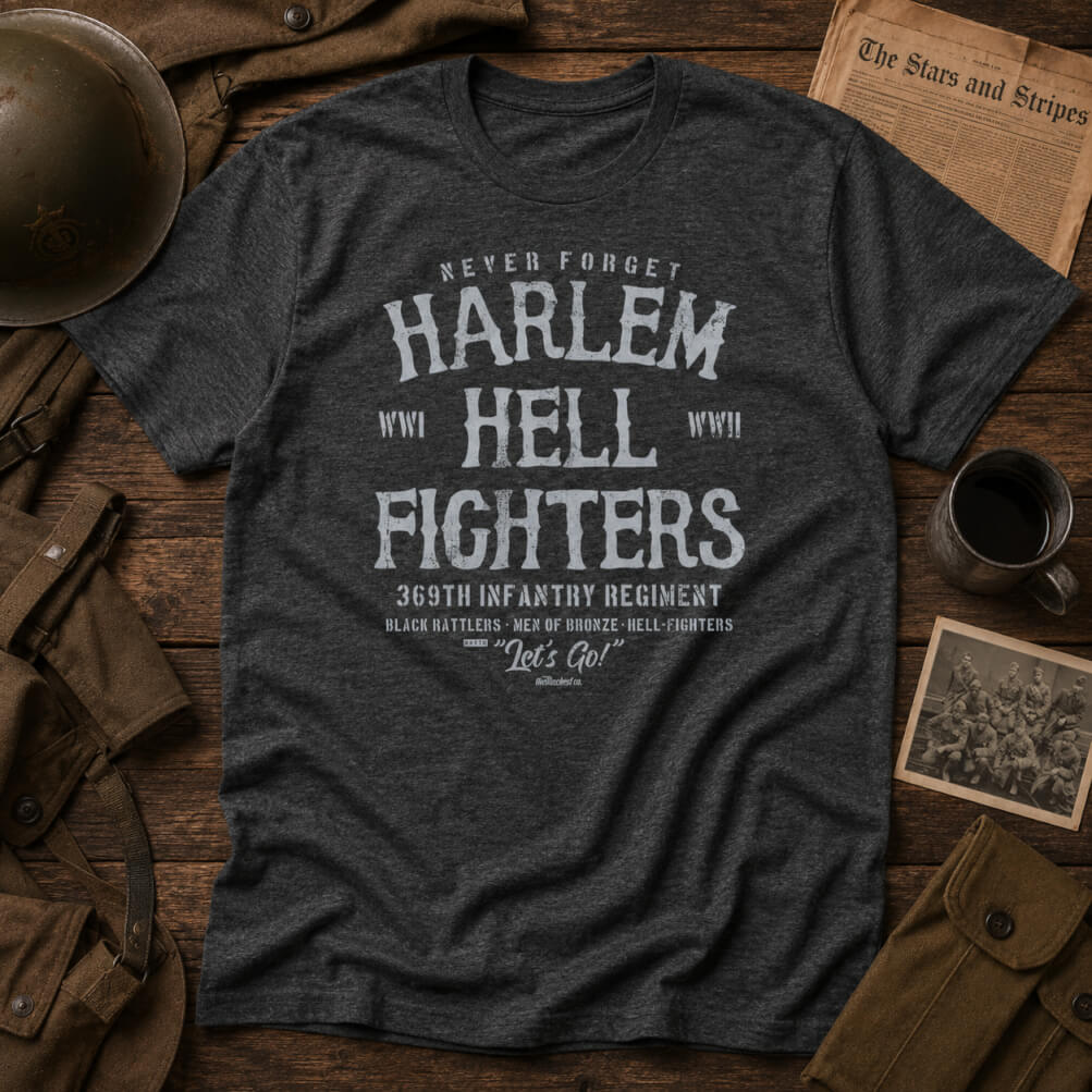 Dark gray t-shirt with 'Harlem Hellfighters' text on a wooden surface with vintage items.