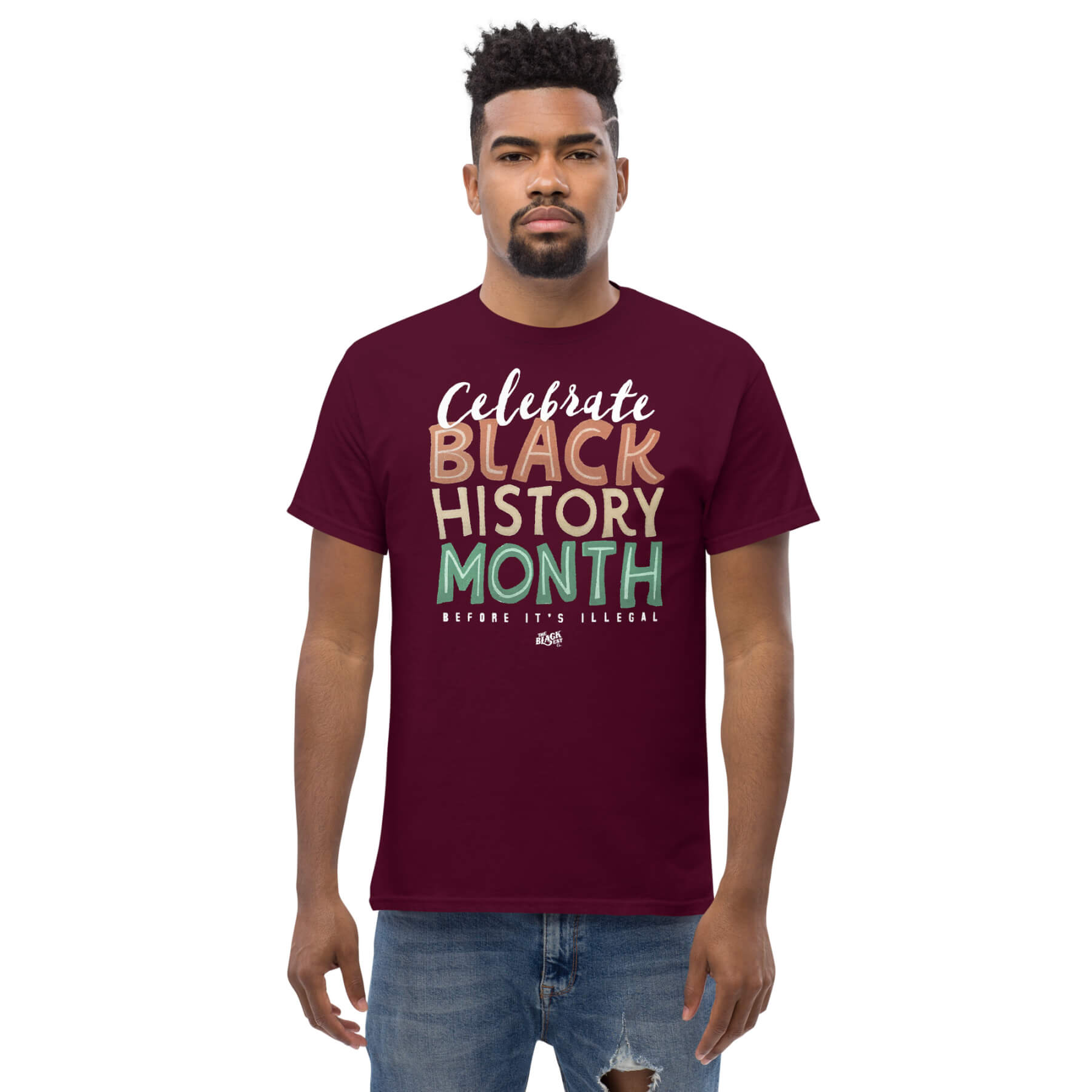 Man wearing a maroon 'Celebrate Black History Month Before It's Illegal' t-shirt. Bold and stylish design for Black History Month.