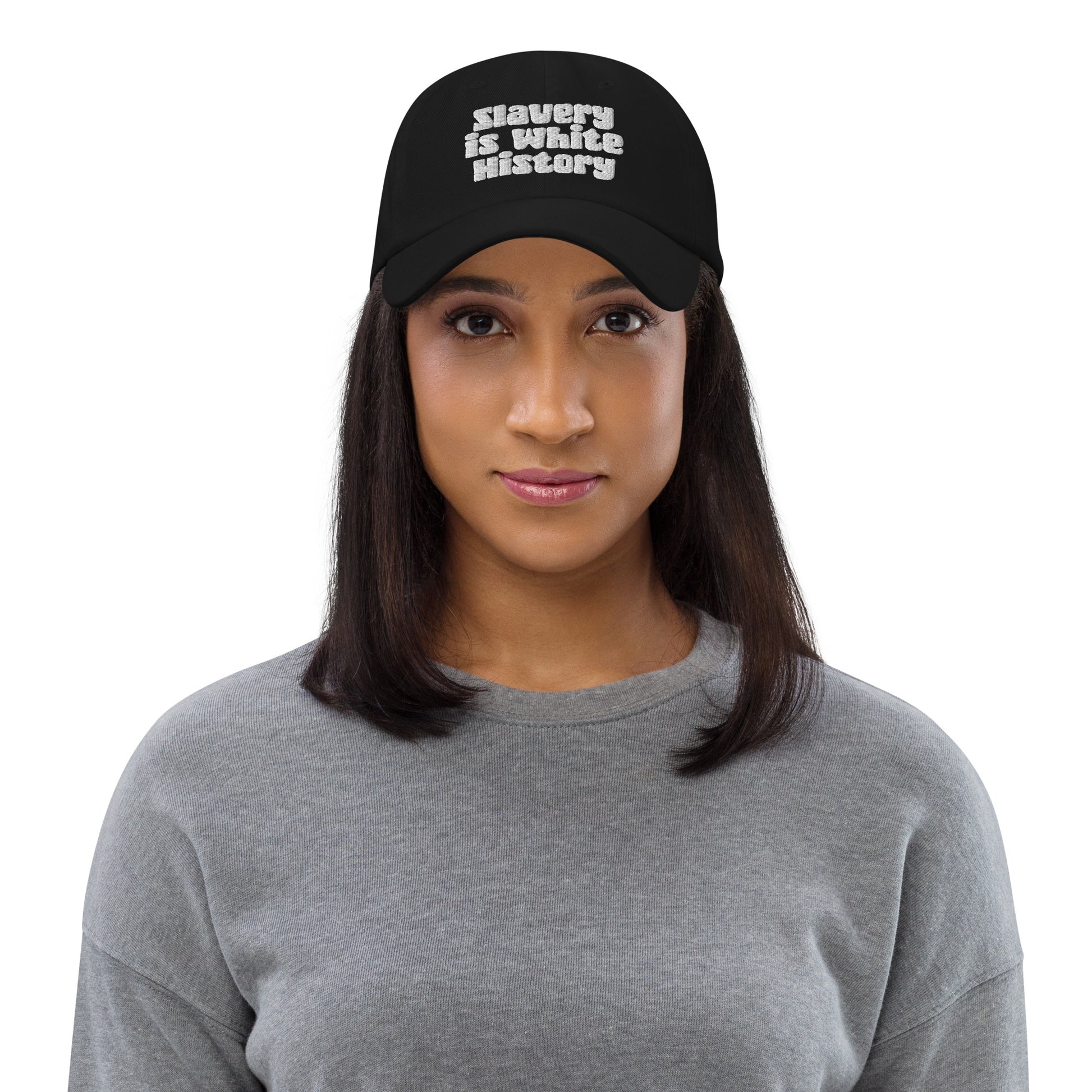 Front view of woman wearing Slavery Is White History Embroidered Dad Hat by TheBlacket Co., showcasing statement text and unstructured fit.