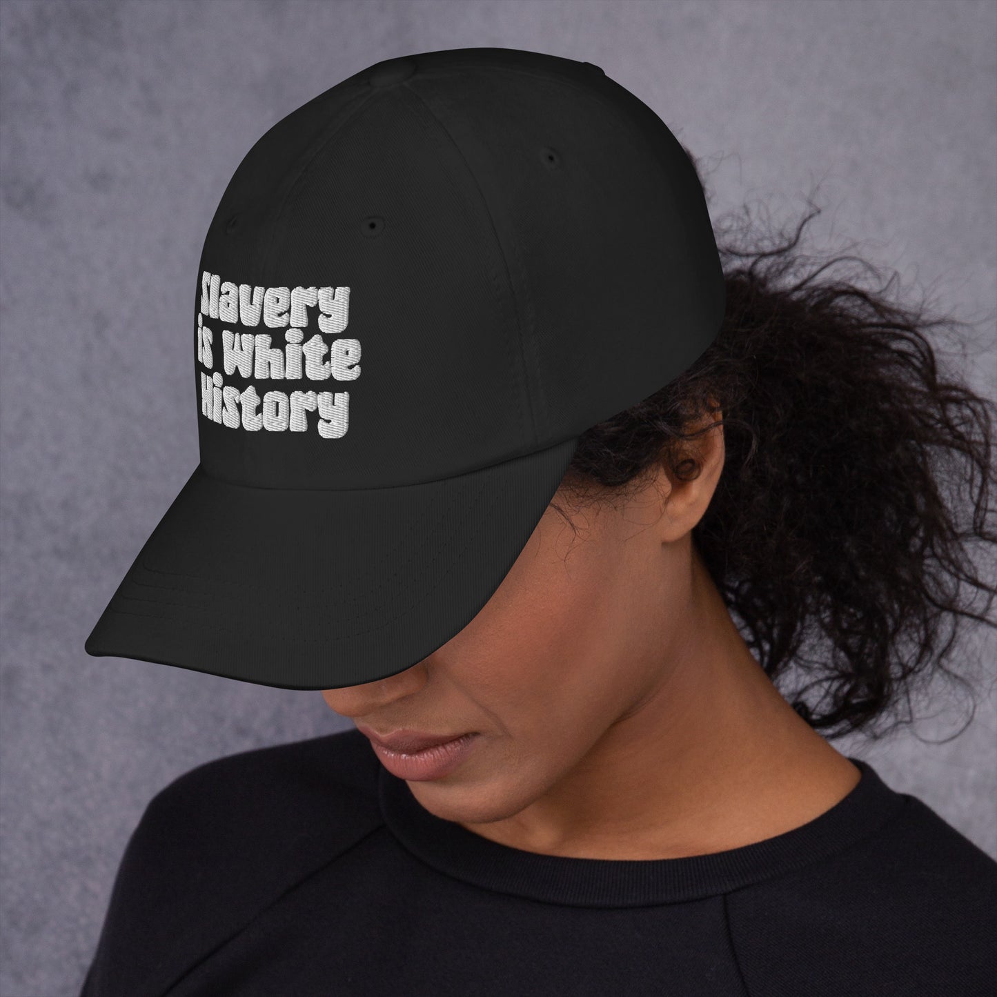 Side view of black Slavery Is White History Embroidered Dad Hat by TheBlacket Co. worn by a woman, highlighting curved brim and bold message.