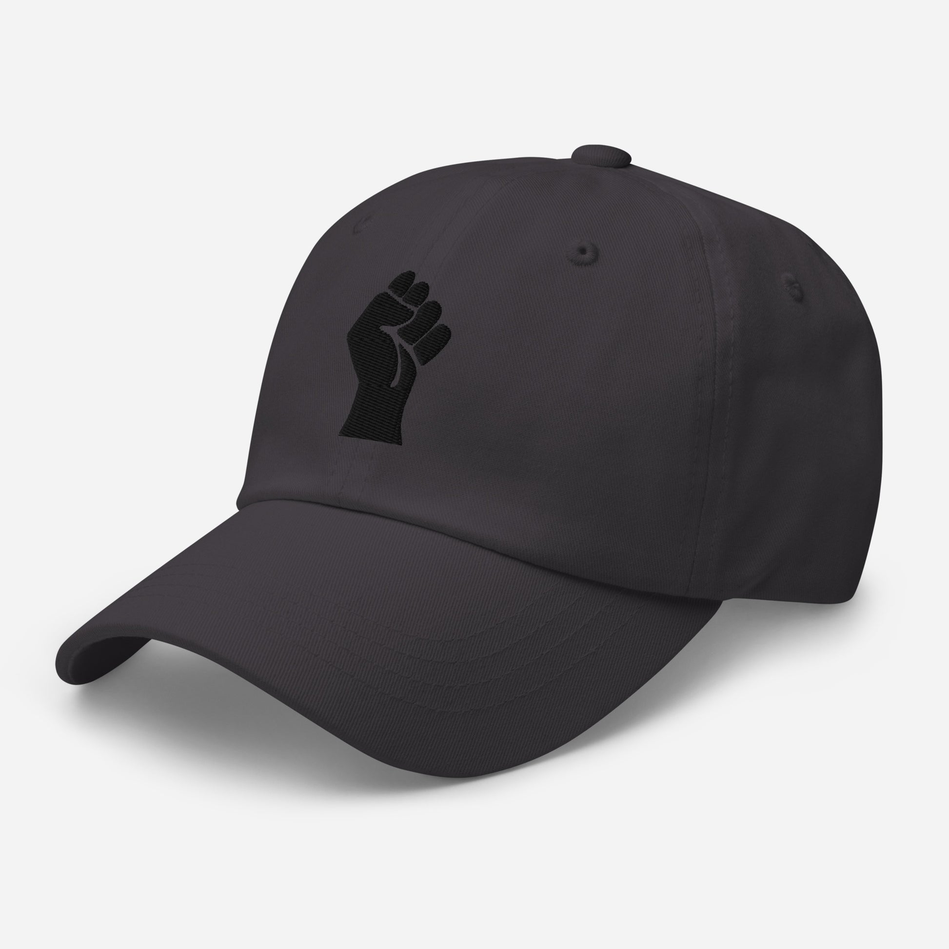 Angled view of Black On Black Power Fist Embroidered Baseball Cap showing detailed embroidery and curved brim for casual style.