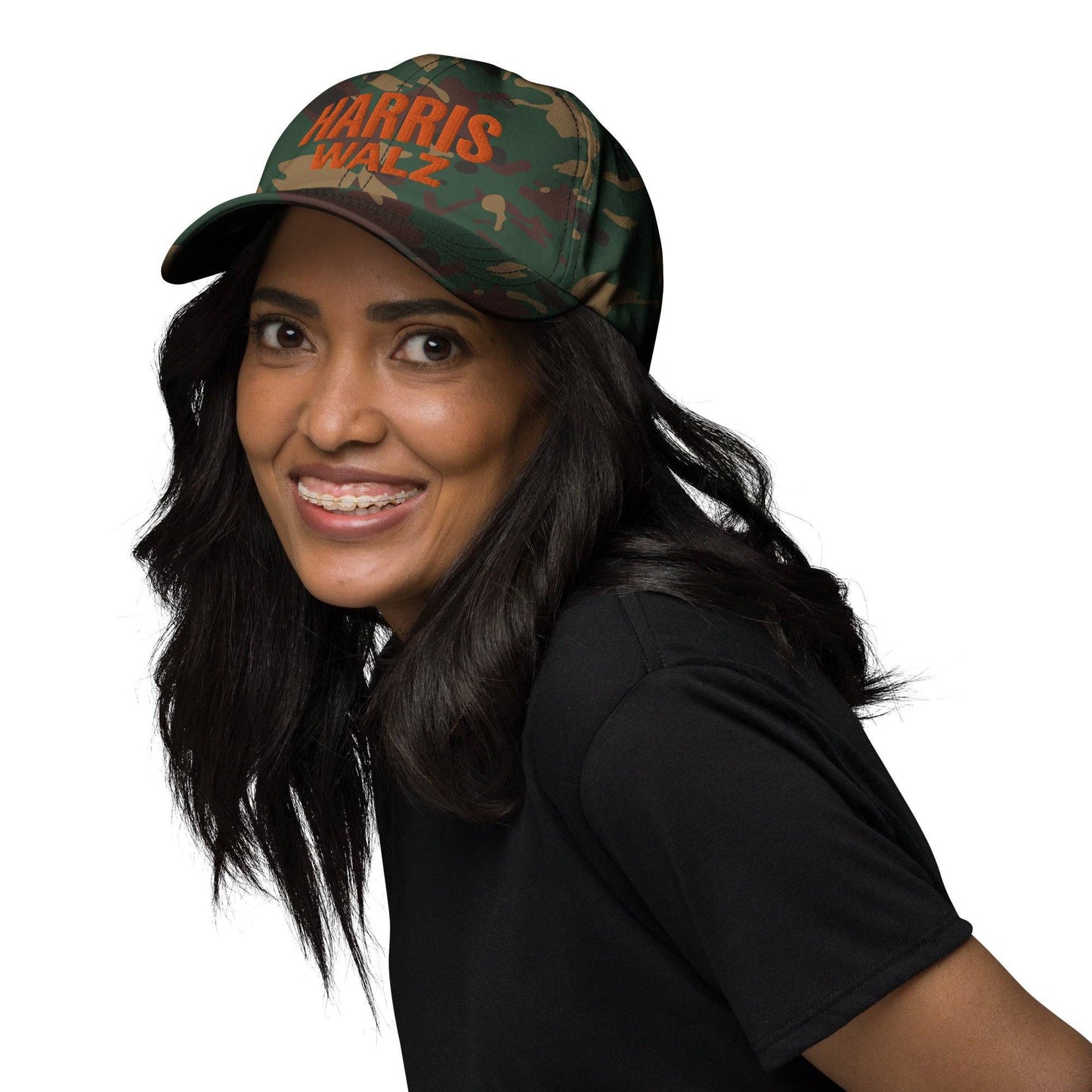 Woman wearing Harris Walz camo dad cap, smiling