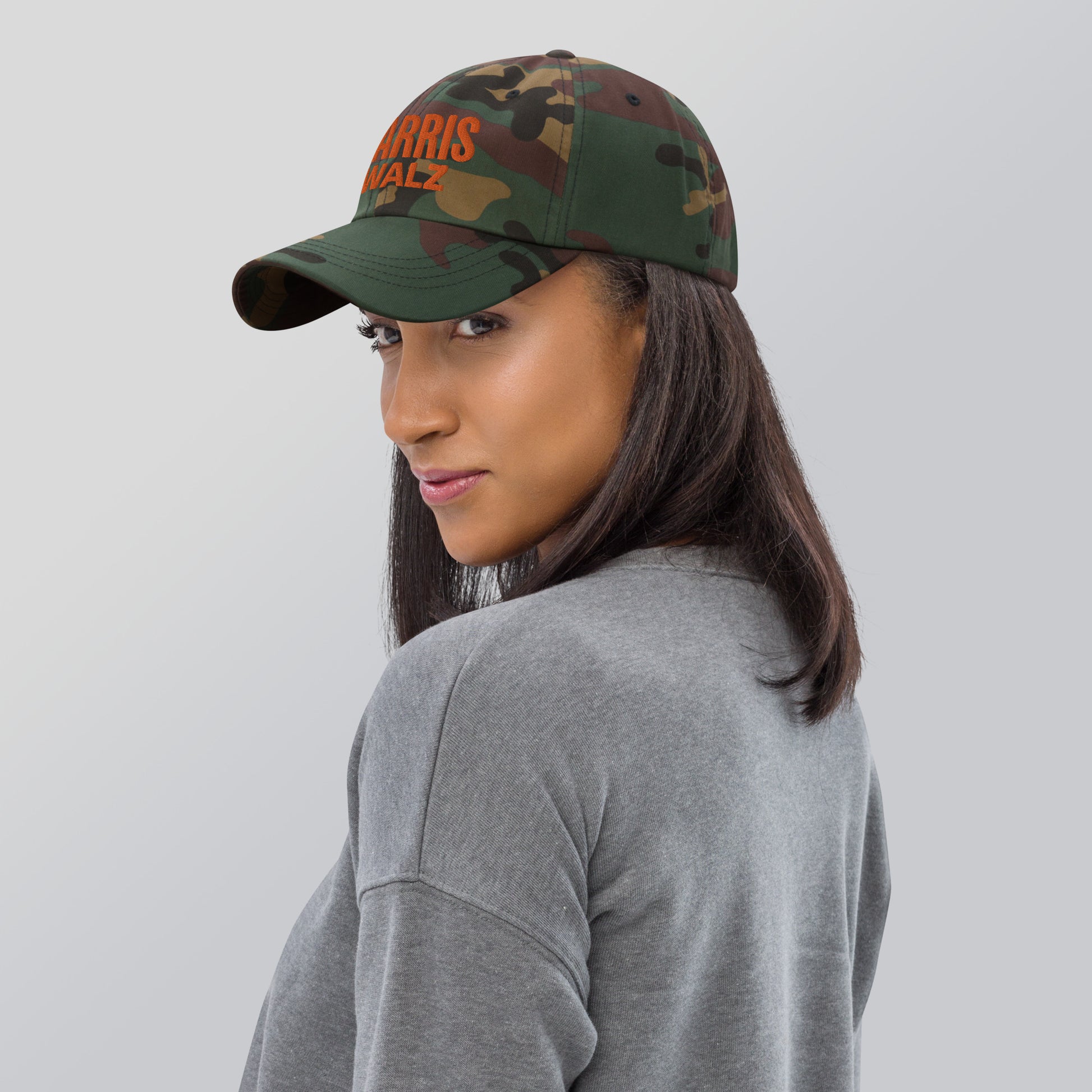 Woman in gray top wearing Harris Walz camo dad cap