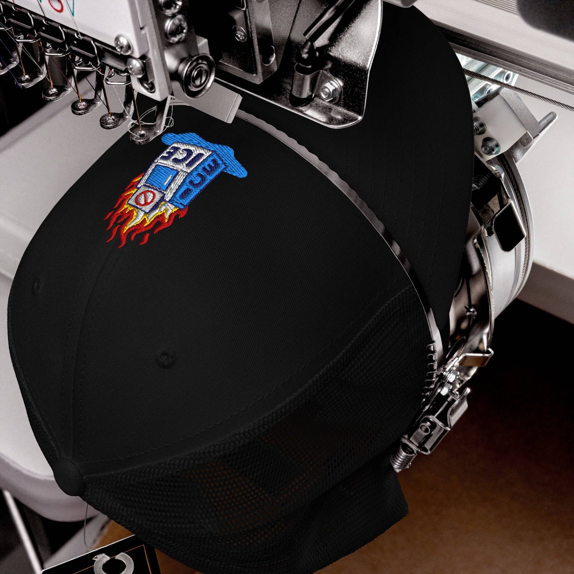 Abolish ICE Burning Machine Trucker Hat by TheBlackest Co. being embroidered on a machine, showcasing high-quality USA craftsmanship.