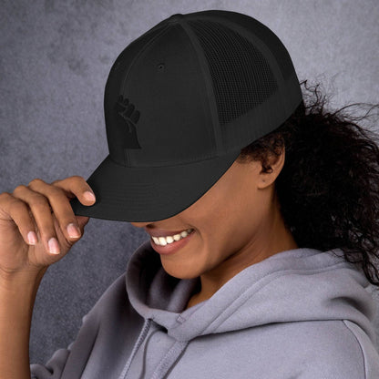 Smiling person wearing Black Power Fist embroidered trucker cap