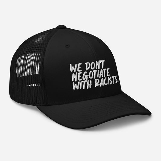 black trucker hat with text that reads we don't negotiate with racists embroidered