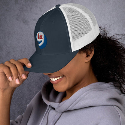 Person wearing Red White Blue Comma La Harris Trucker Cap