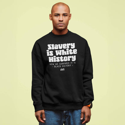 Man wearing a black 'Slavery Is White History' unisex sweatshirt by TheBlackest Co., styled with casual jeans against a light background.