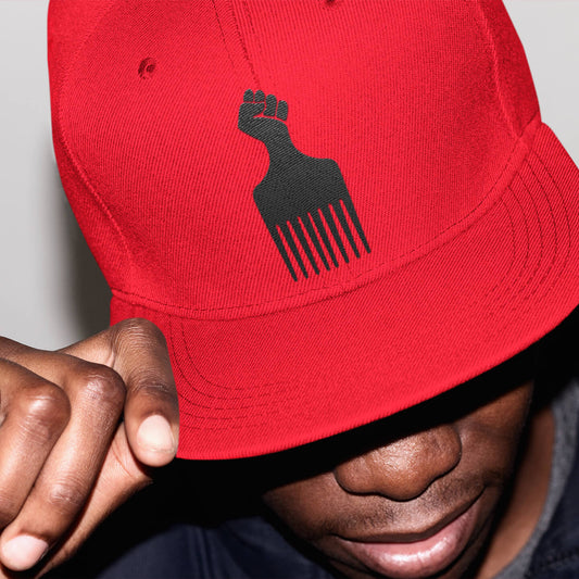 man wearing a red snapback hat with a black power fist pick embroidered on it