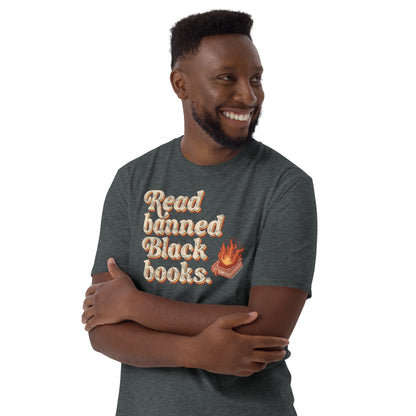 Man wearing a dark gray 'Read Banned Black Books' t-shirt with a flaming book graphic, styled casually and smiling confidently.