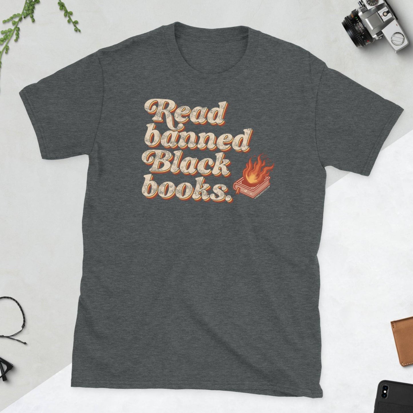 Dark gray unisex t-shirt with 'Read Banned Black Books' text and a flaming book graphic, styled for book lovers and advocates of Black literature.