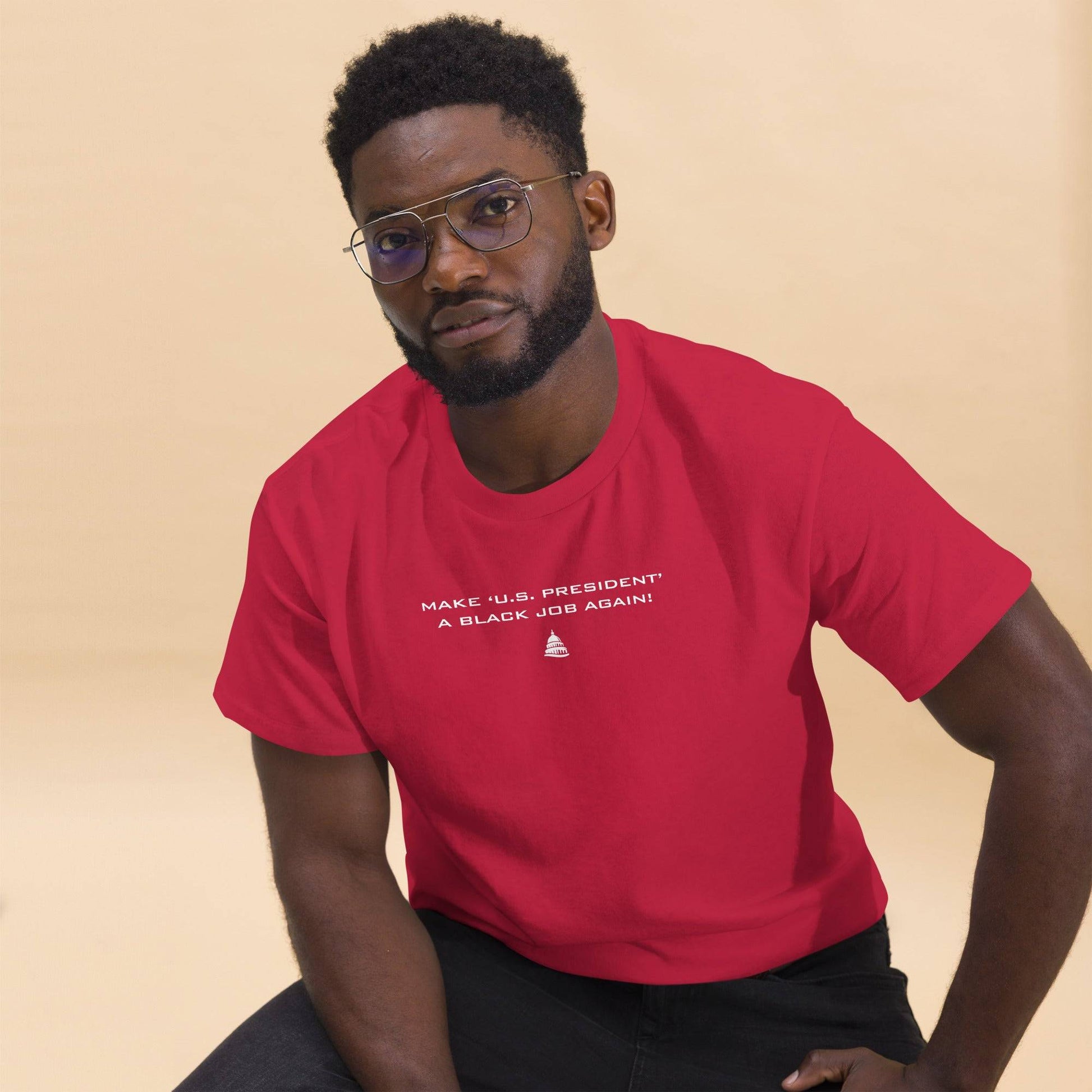 Man seated in red 'Make U.S. President A Black Job Again' t-shirt