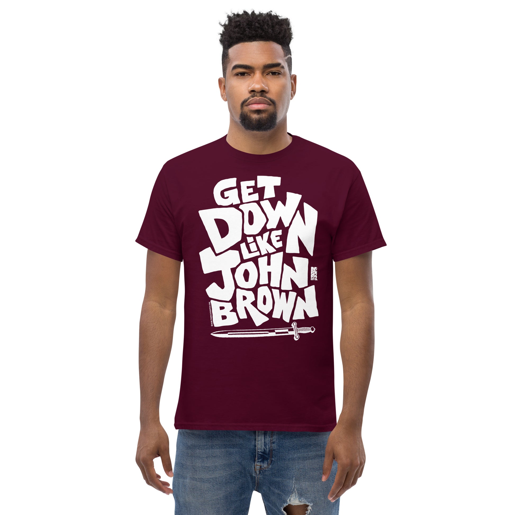 Unisex graphic t-shirt in maroon with bold white text reading 'Get Down Like John Brown' and a sword illustration at the bottom, casual everyday wear