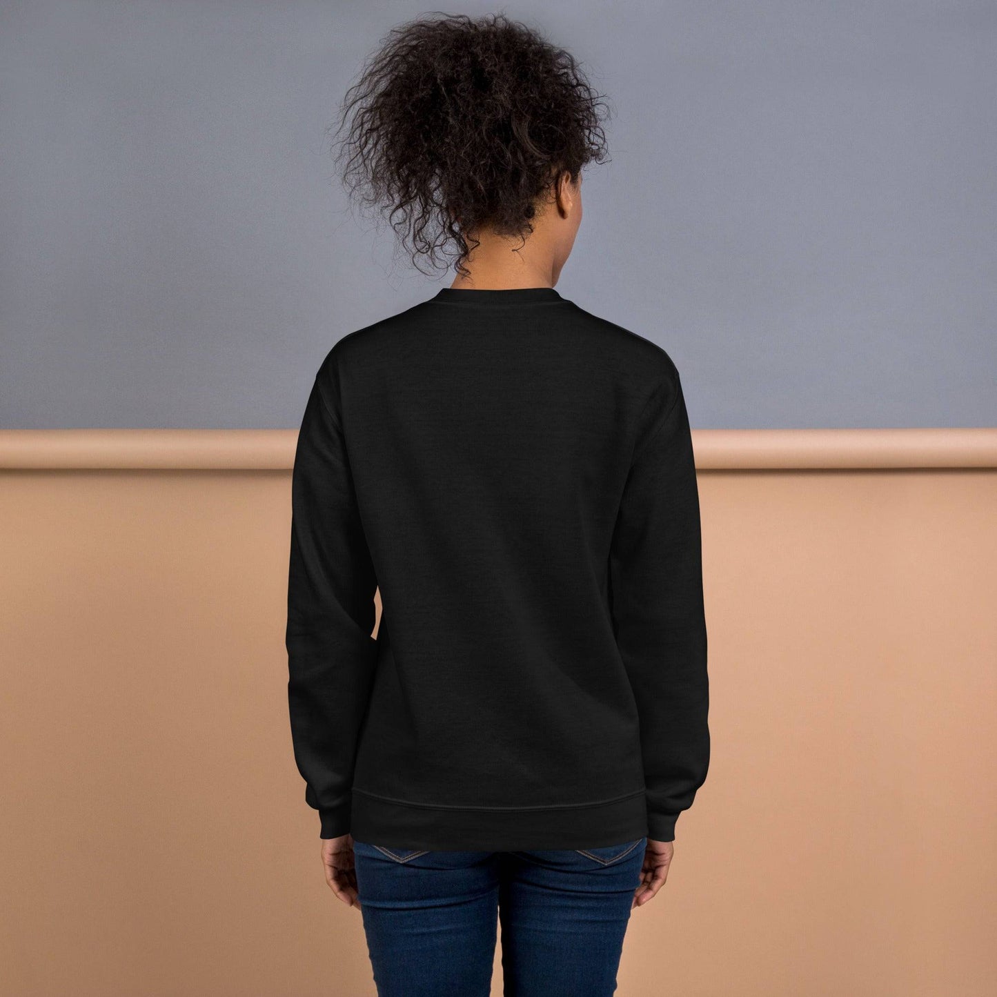 Back view of a black sweatshirt with a plain design, showcasing its comfortable fit and unisex style.