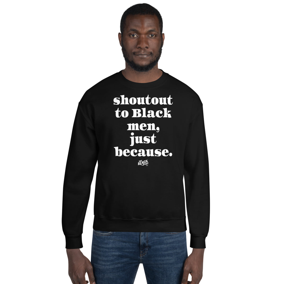 Black man wearing a black unisex sweatshirt with bold white text reading 'shoutout to Black men just because' on a plain white background